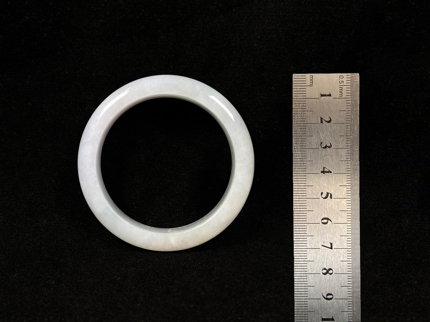 This creamy white jadeite bangle carries soft golden undertones, exuding warmth and elegance.