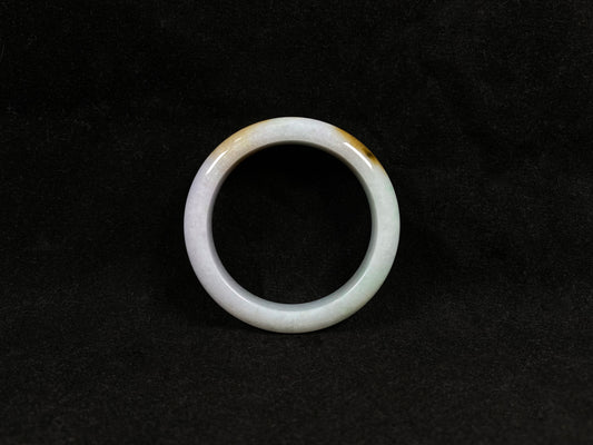 A  white jadeite bangle featuring purple, gold, and light green tones.