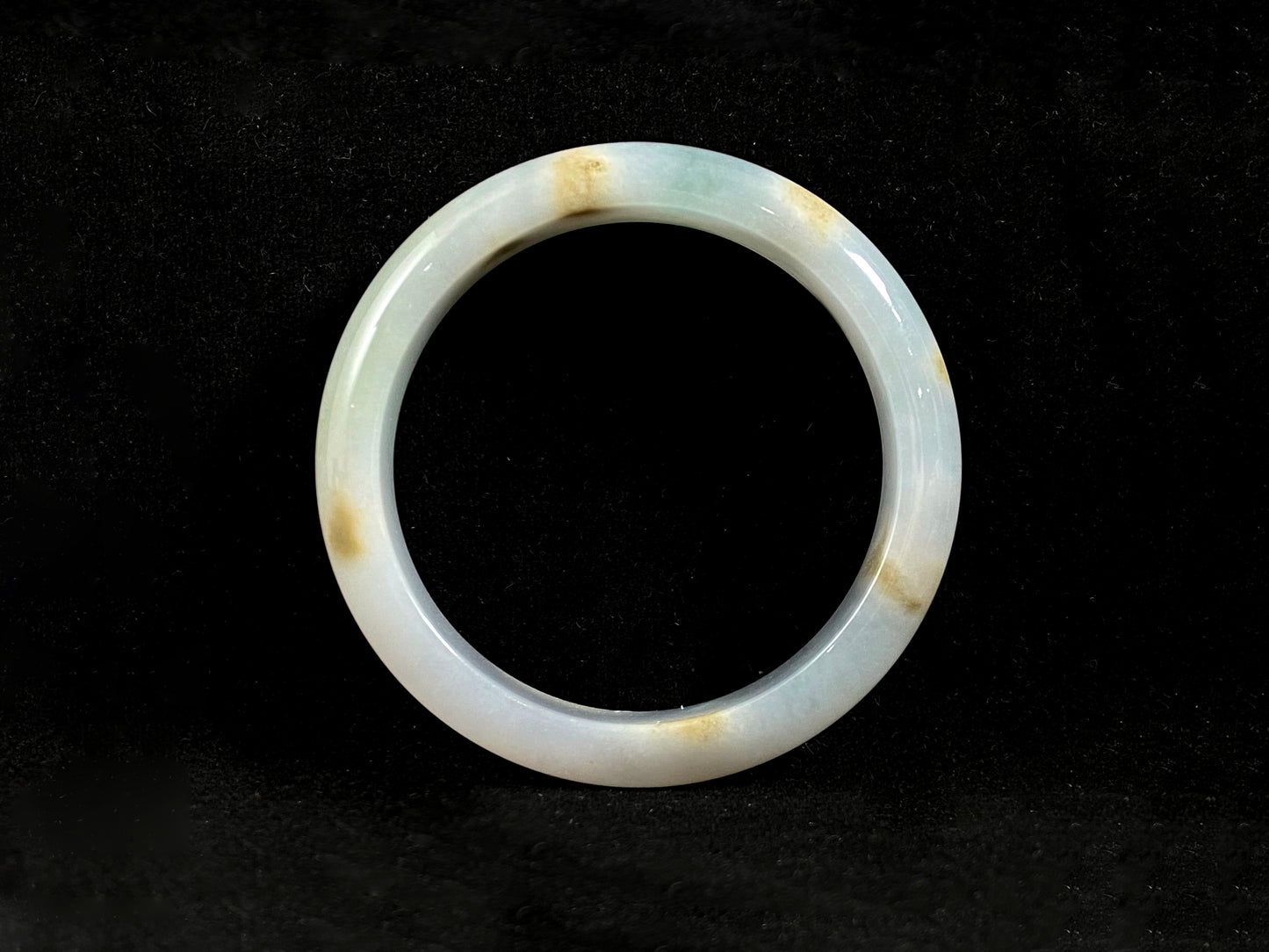 Natural ivory jade bangle with speckled gold and subtle green tones.