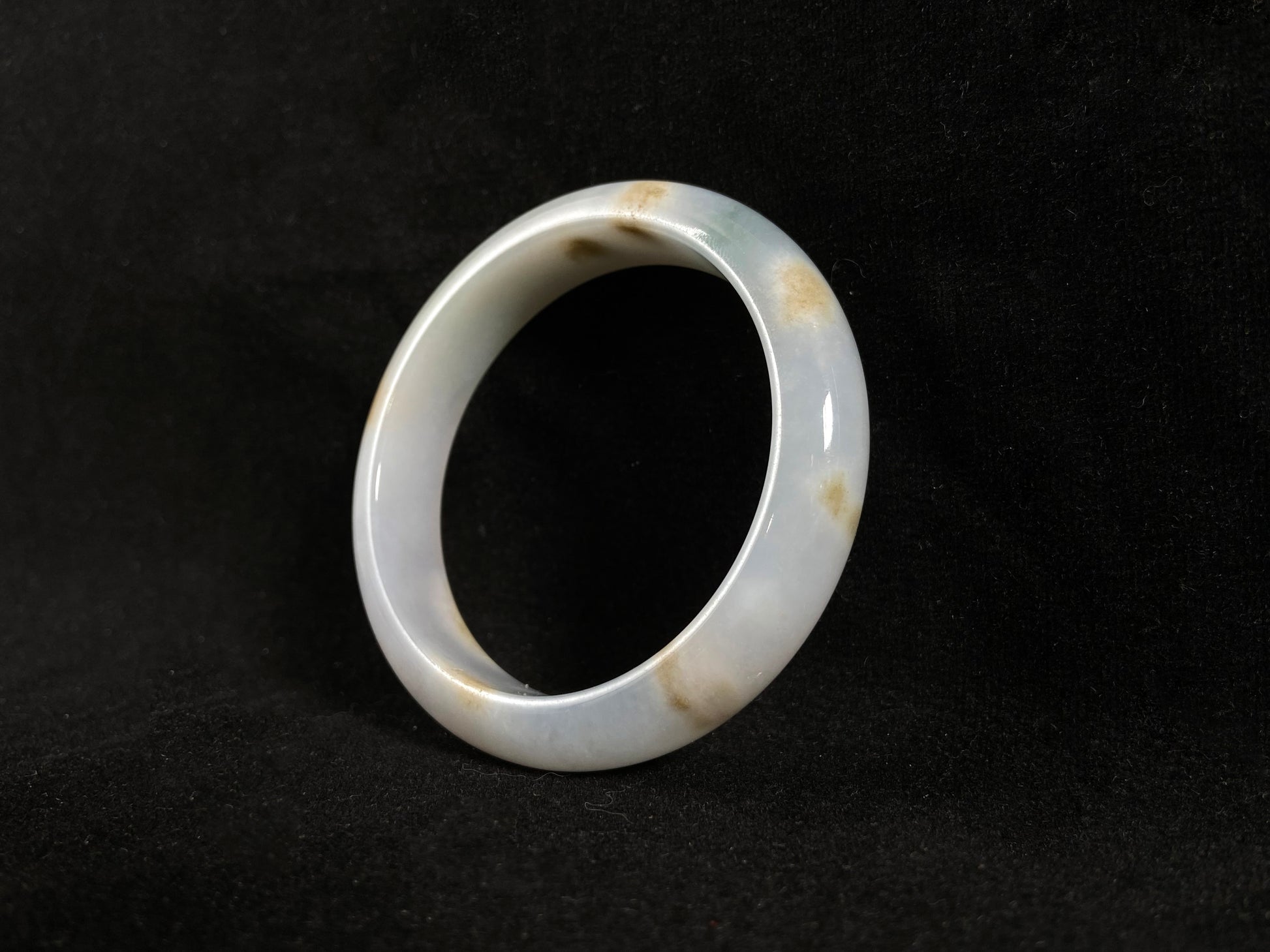 Natural ivory jade bangle with speckled gold and subtle green tones.