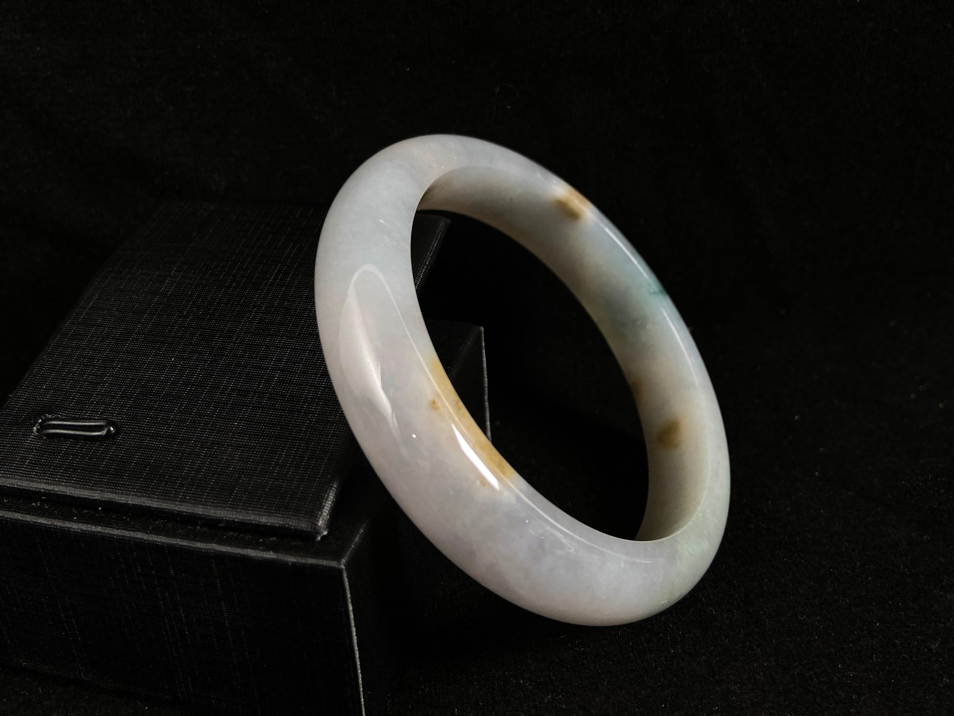 Natural ivory jade bangle with speckled gold and subtle green tones.