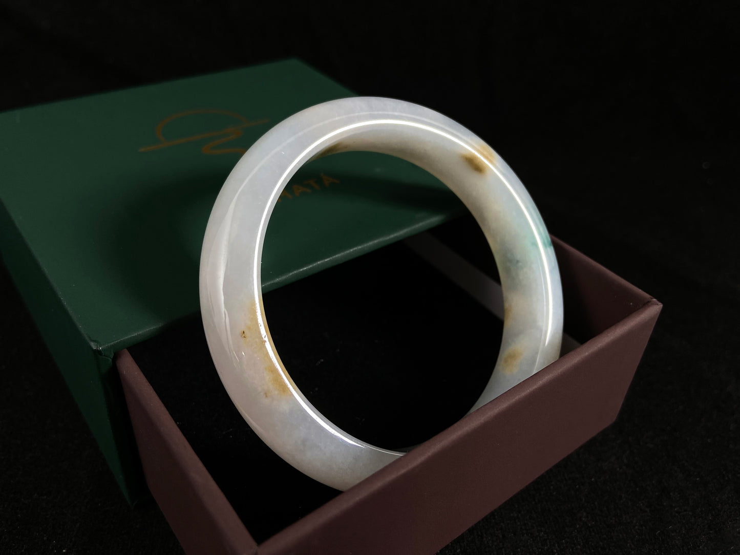 Natural ivory jade bangle with speckled gold and subtle green tones.