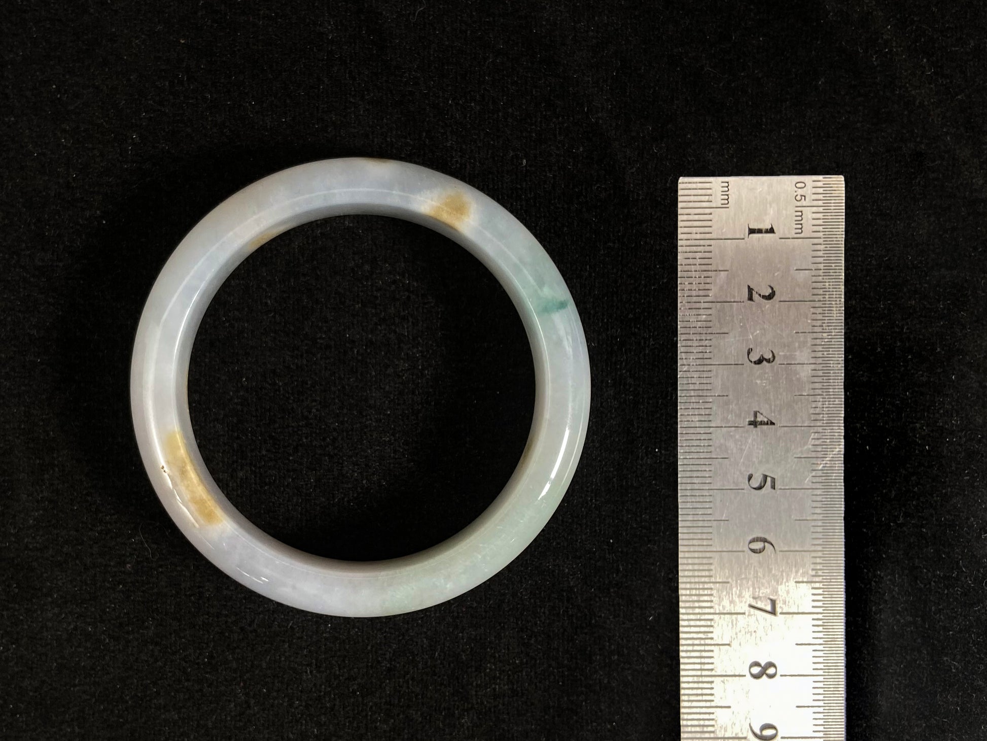 Natural ivory jade bangle with speckled gold and subtle green tones.