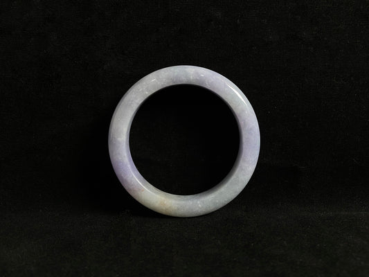 This exquisite jade bangle features a pristine white base adorned with delicate purple accents, creating an elegant color contrast.