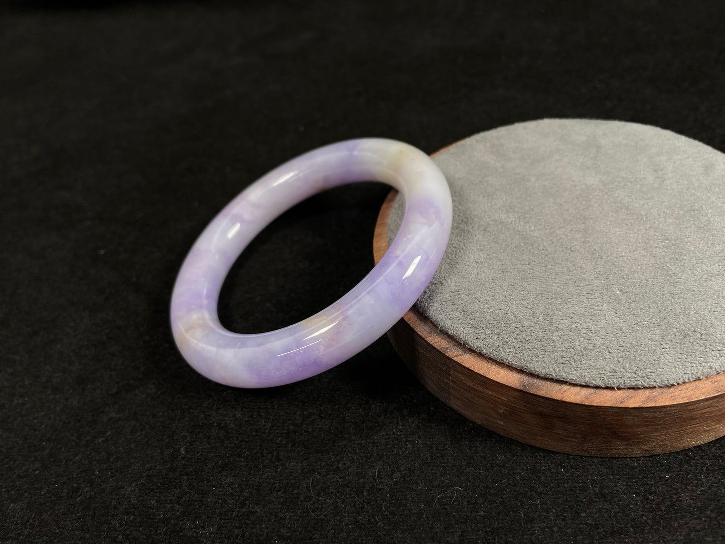 An elegant purple jadeite bangle delicately adorned with gold accents.