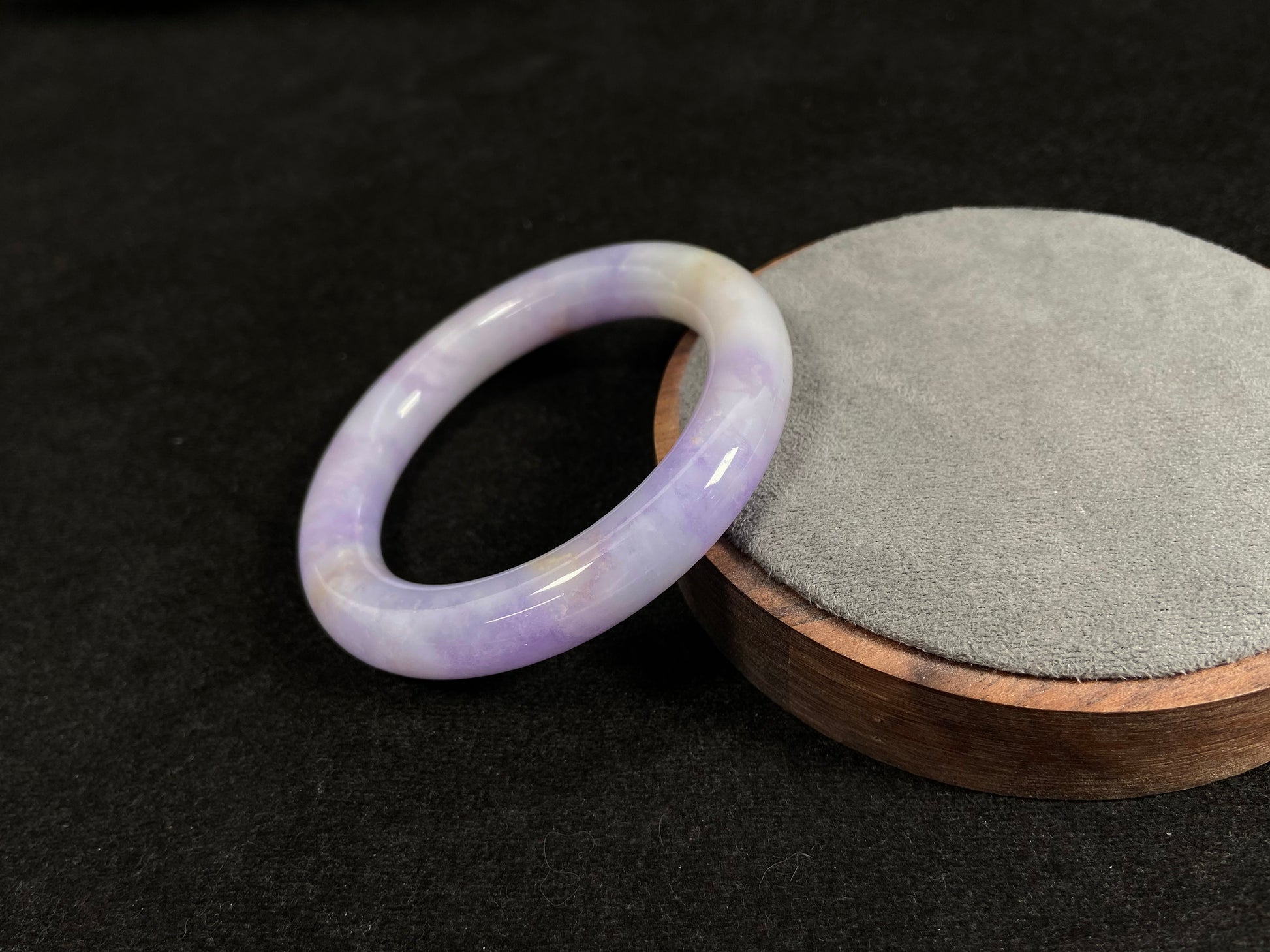 An elegant purple jadeite bangle delicately adorned with gold accents.