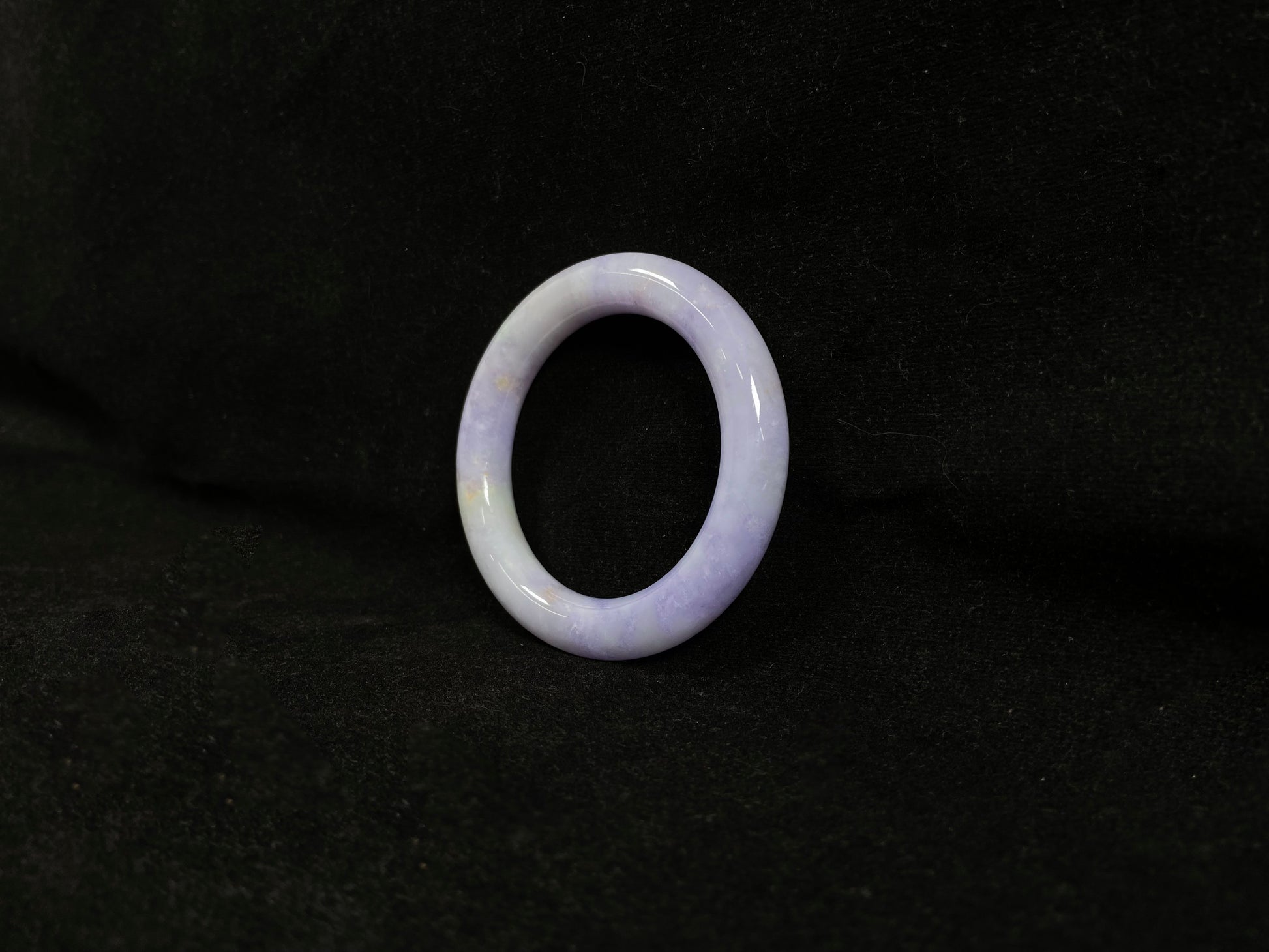 An elegant purple jadeite bangle delicately adorned with gold accents.