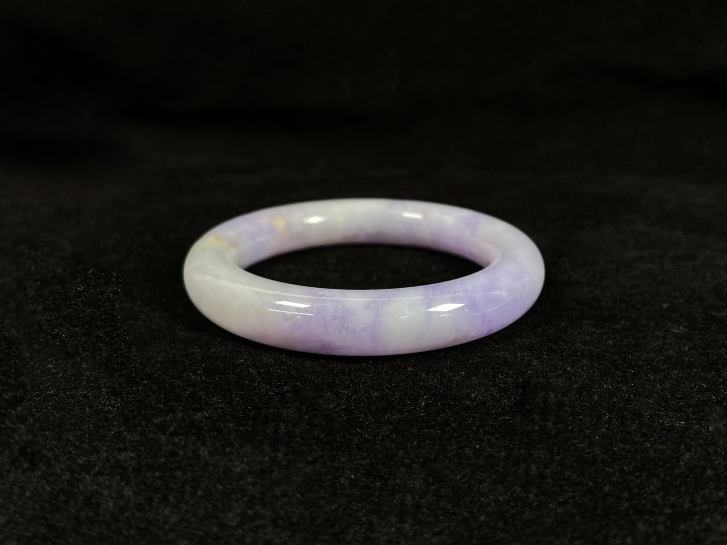 An elegant purple jadeite bangle delicately adorned with gold accents.