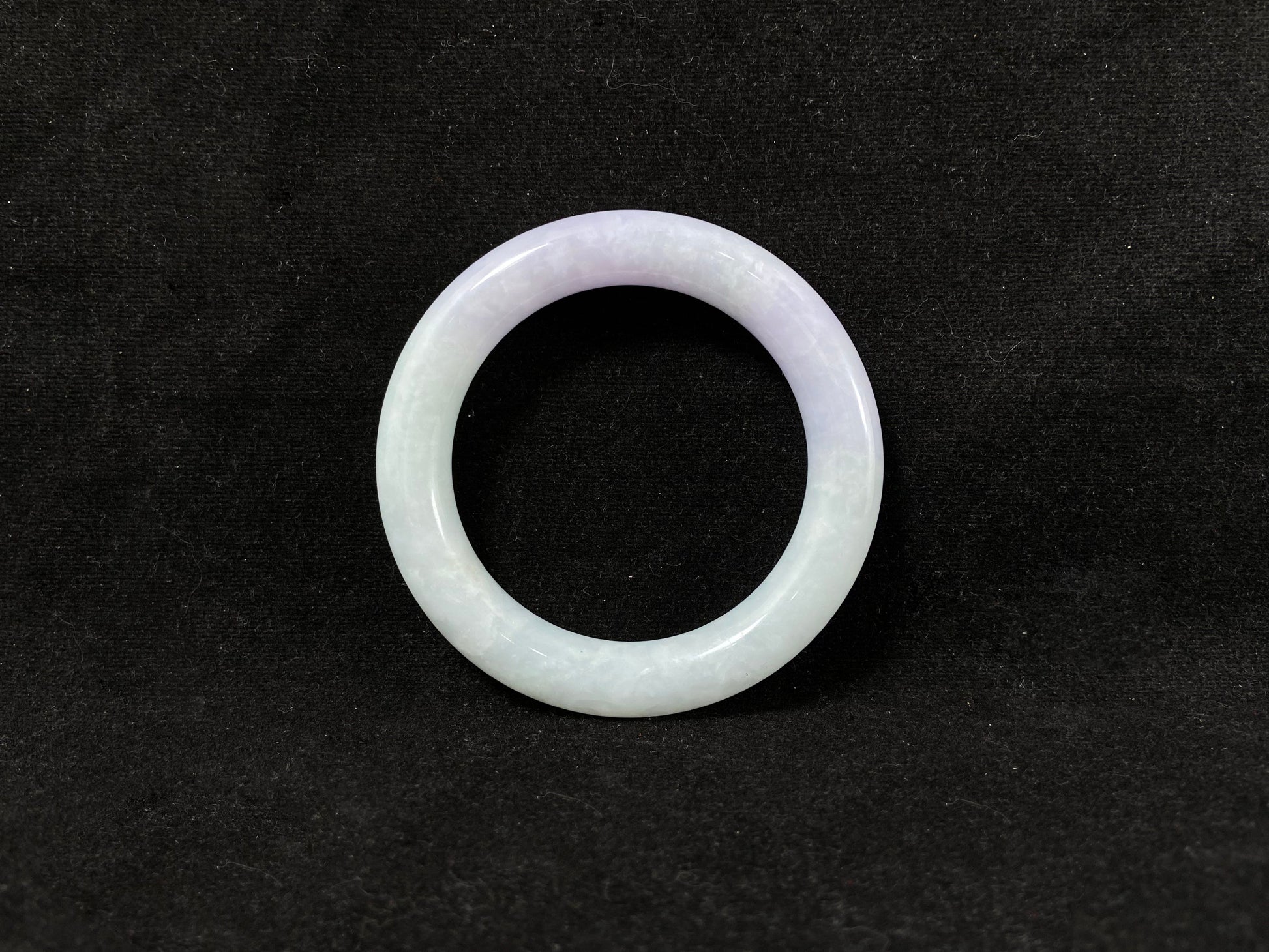 A Fu bangle featuring half light purple and half light green jade.