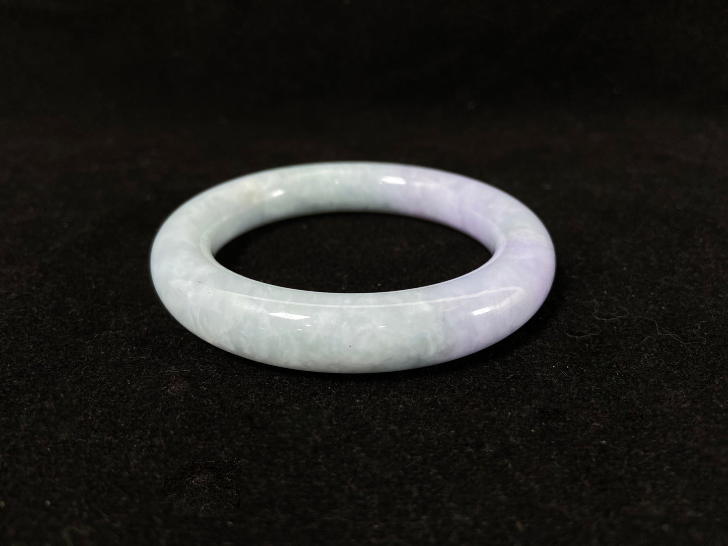 A Fu bangle featuring half light purple and half light green jade.