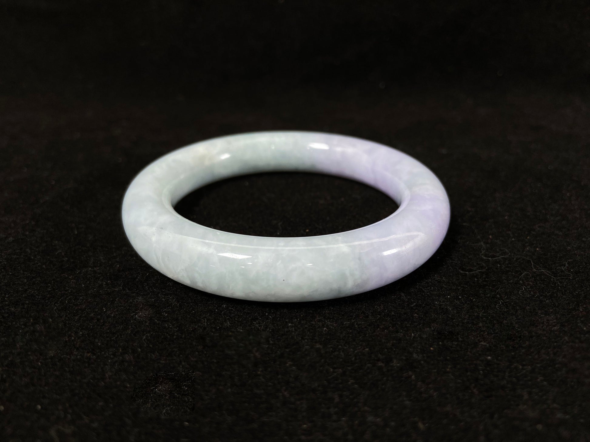 A Fu bangle featuring half light purple and half light green jade.