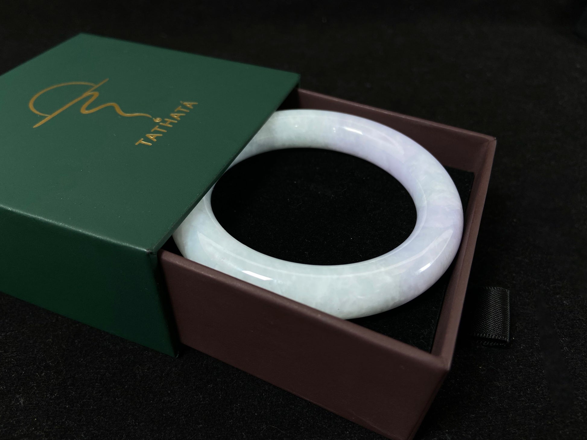 A Fu bangle featuring half light purple and half light green jade.