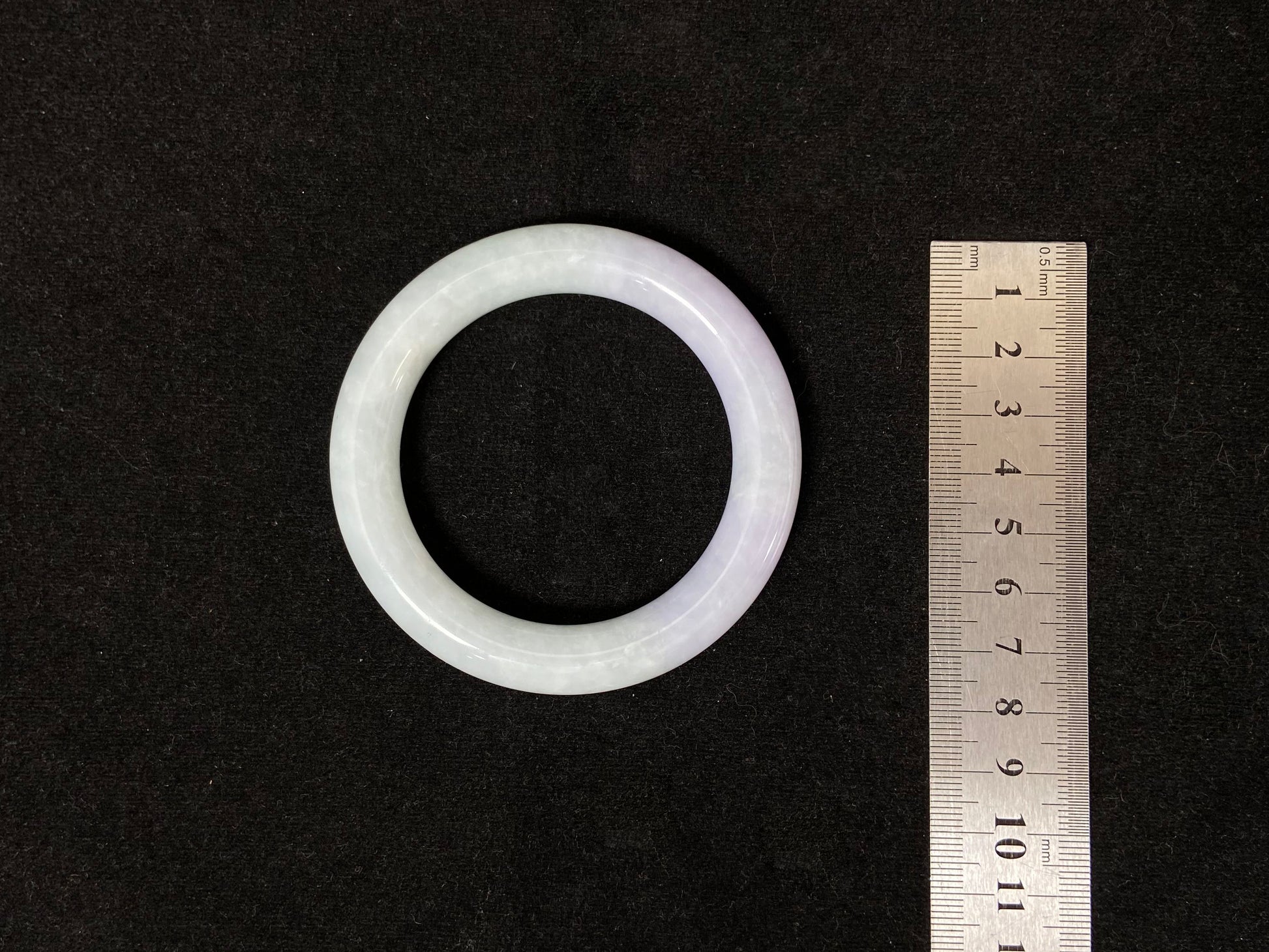 A Fu bangle featuring half light purple and half light green jade.