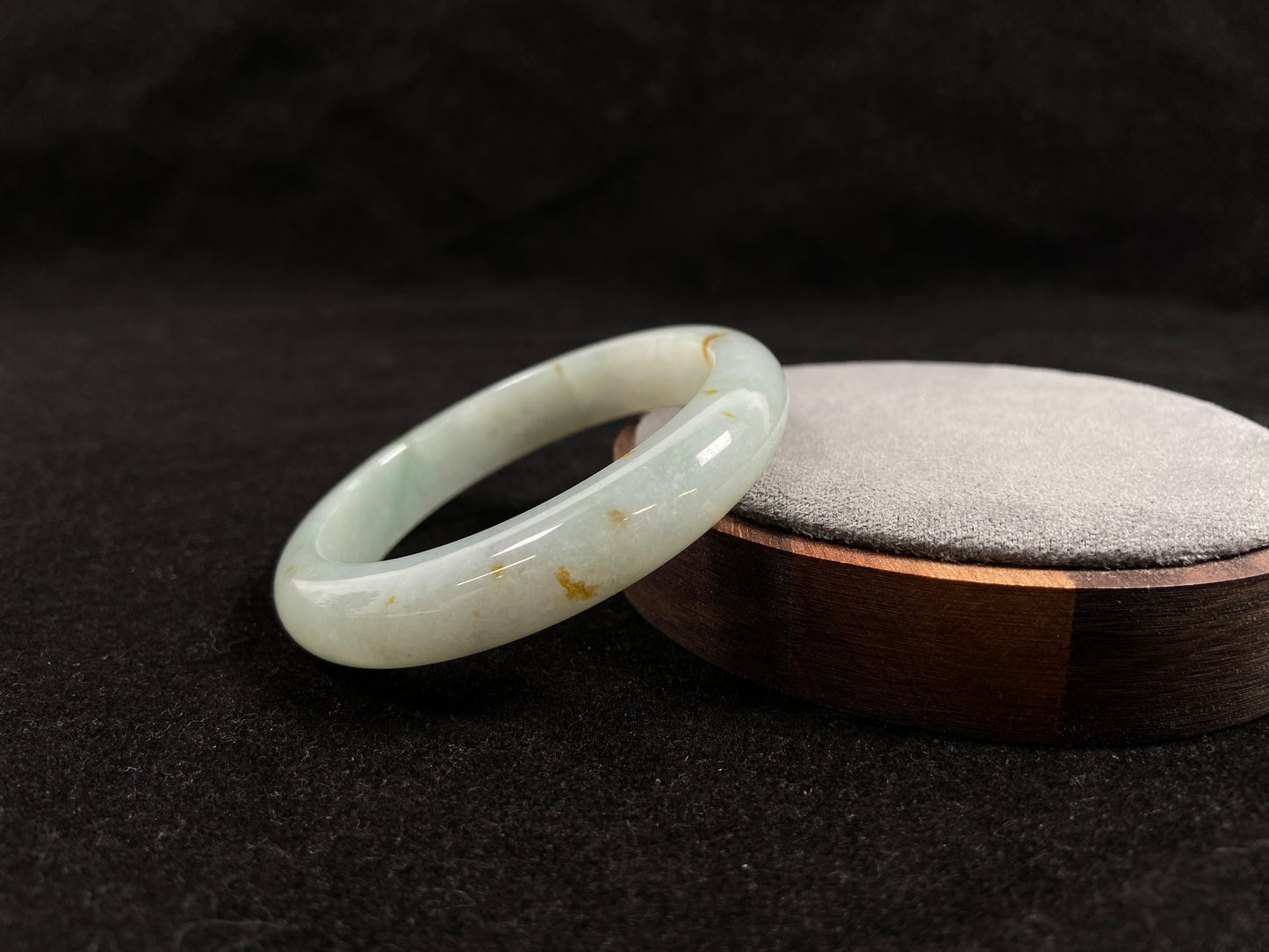 A light green jadeite bangle with gold flecks.