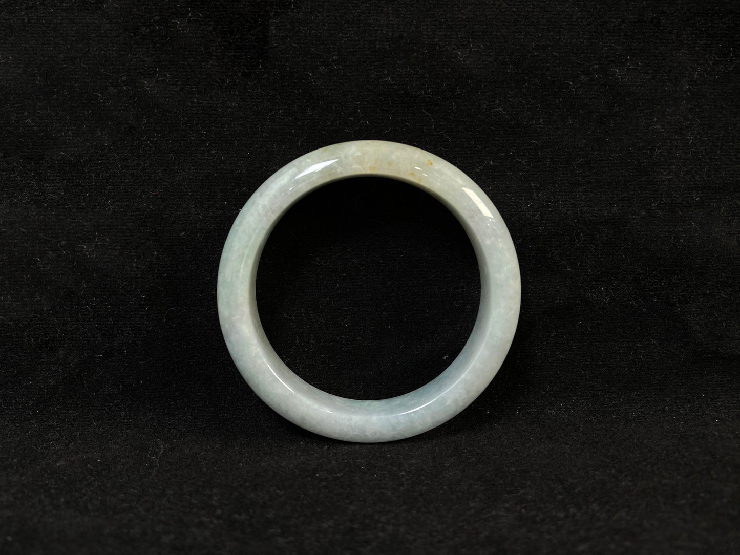 A creamy white jade bangle delicately sprinkled with gold.