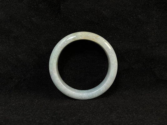 A creamy white jade bangle delicately sprinkled with gold.