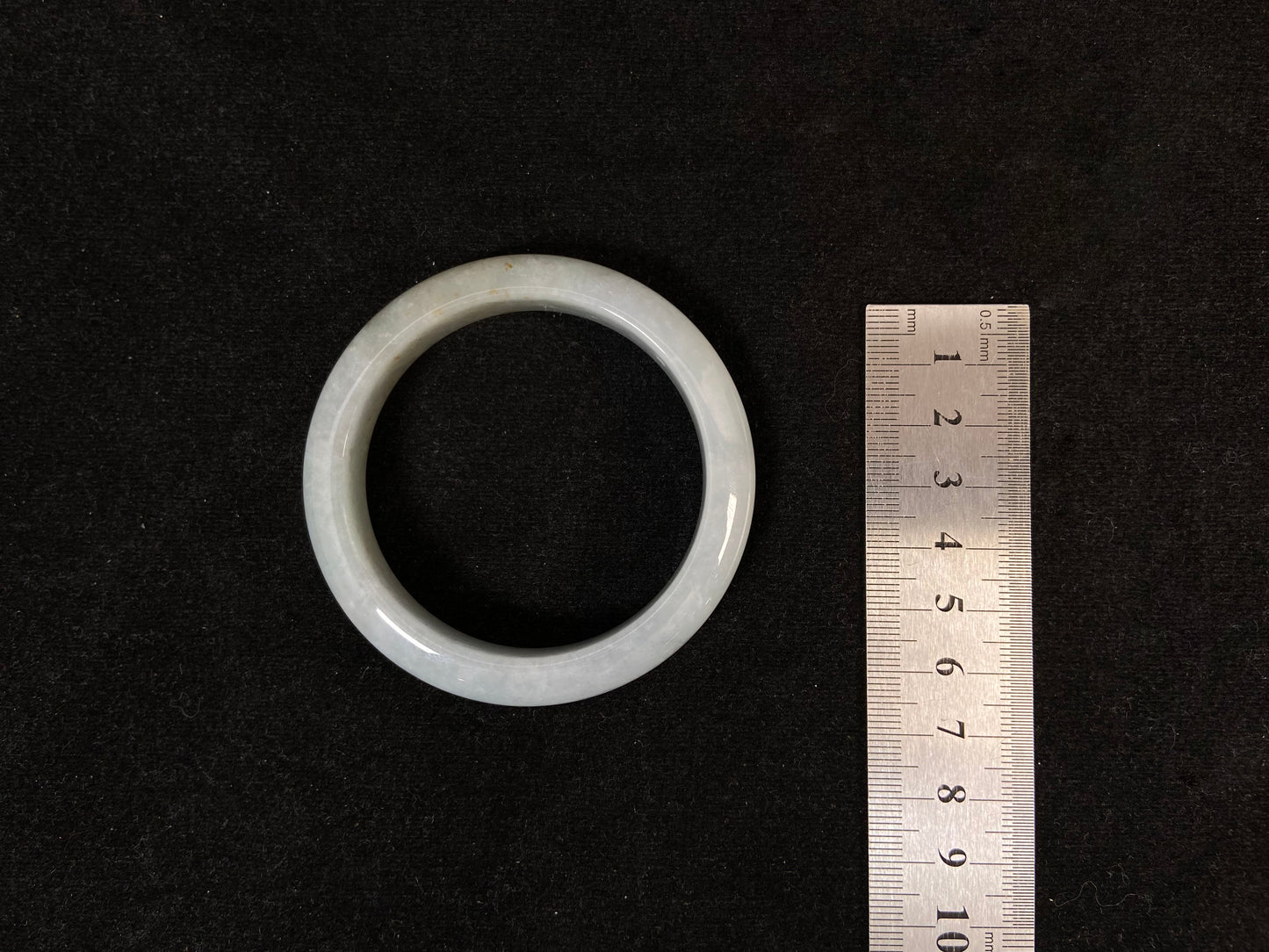 A creamy white jade bangle delicately sprinkled with gold.