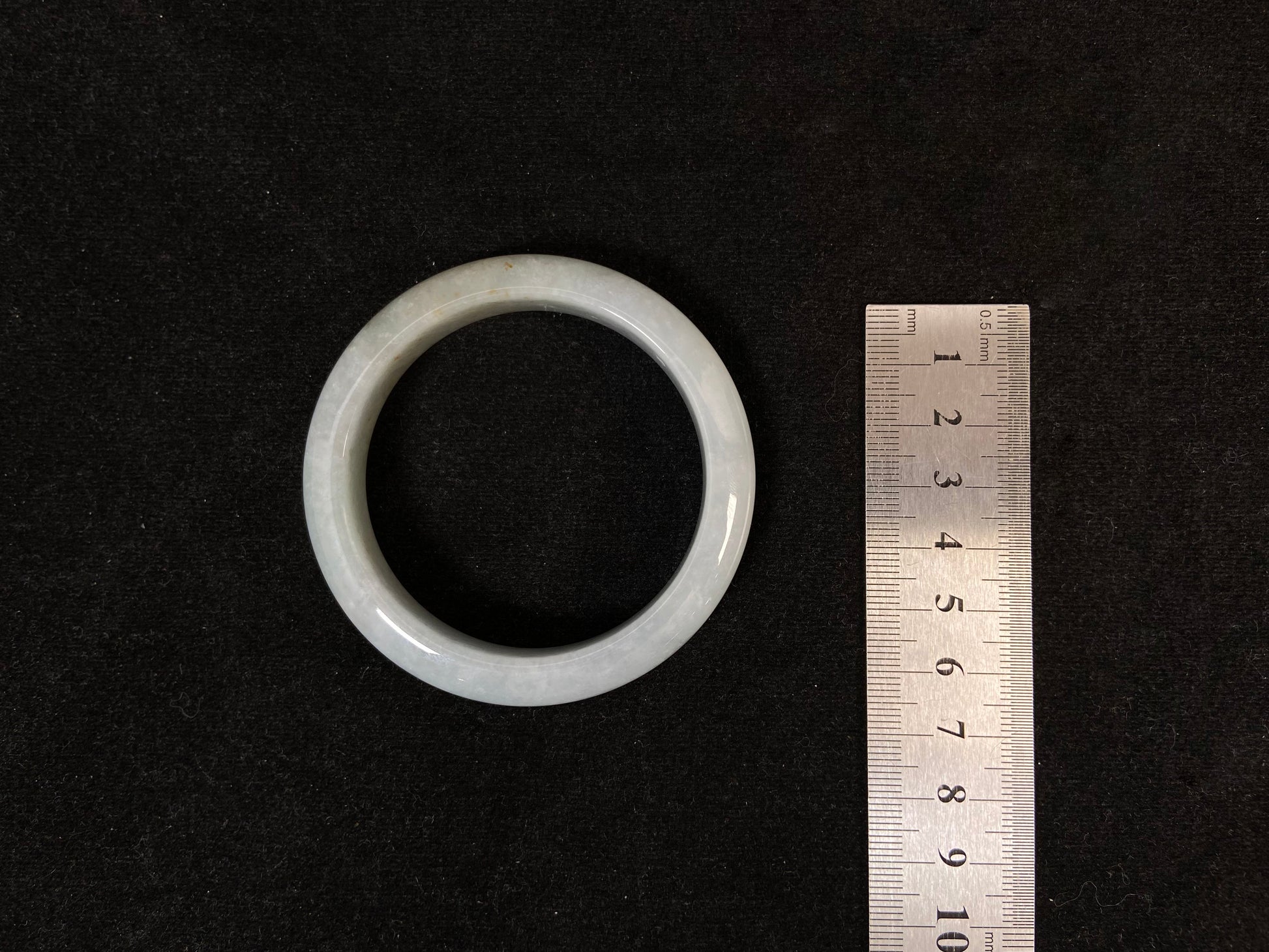 A creamy white jade bangle delicately sprinkled with gold.