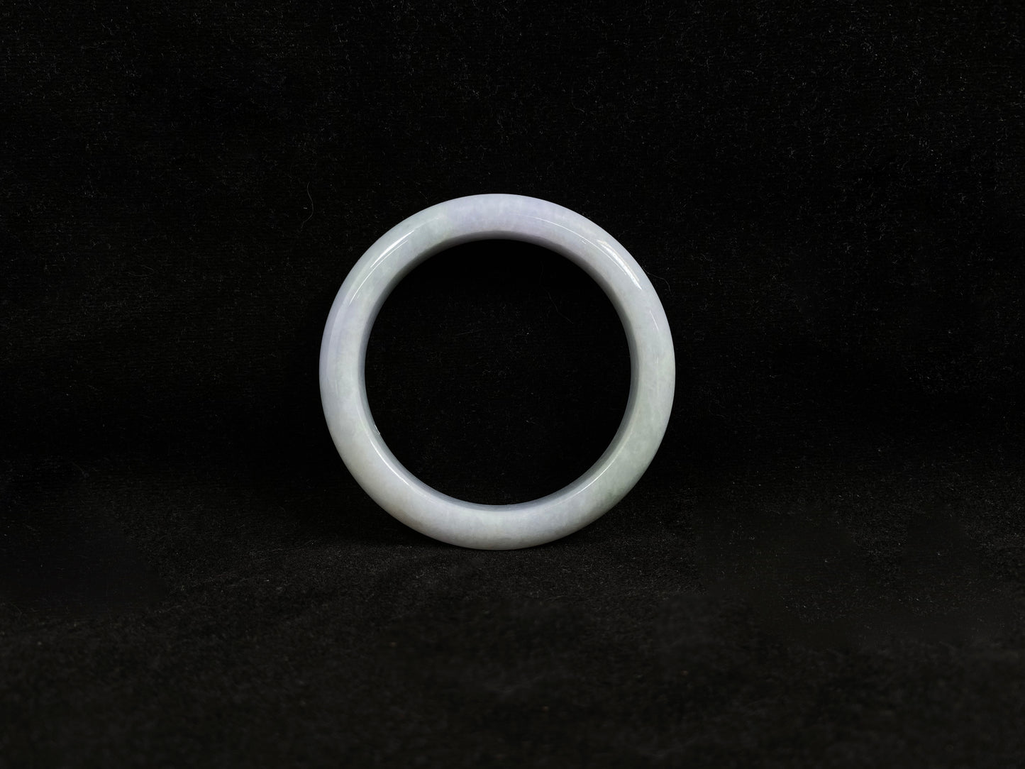 This jadeite bangle blends white and pale purple with golden accents.