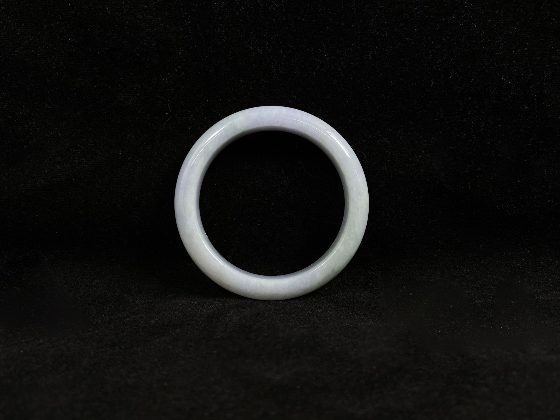 This jadeite bangle blends white and pale purple with golden accents.