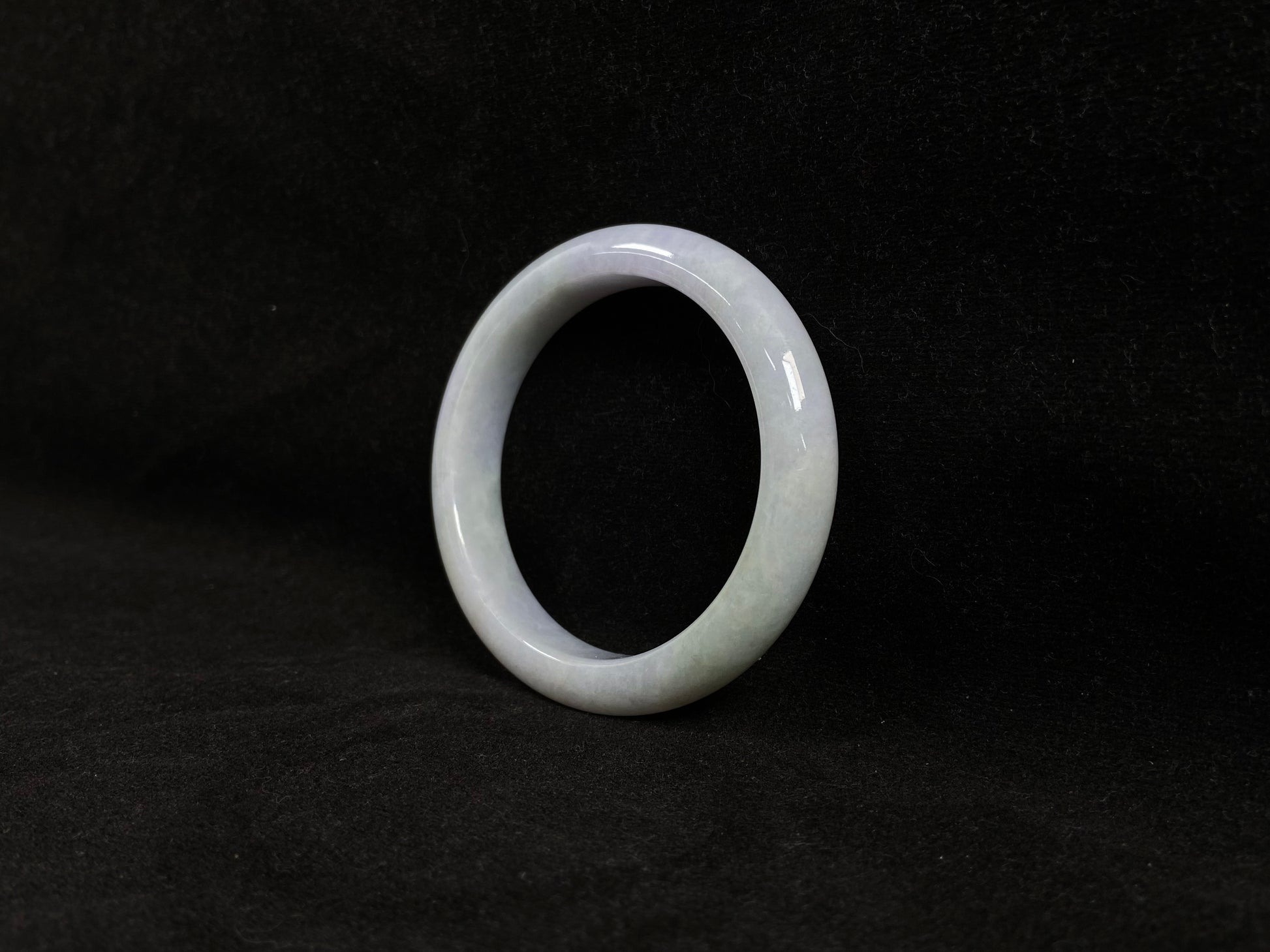 This jadeite bangle blends white and pale purple with golden accents.