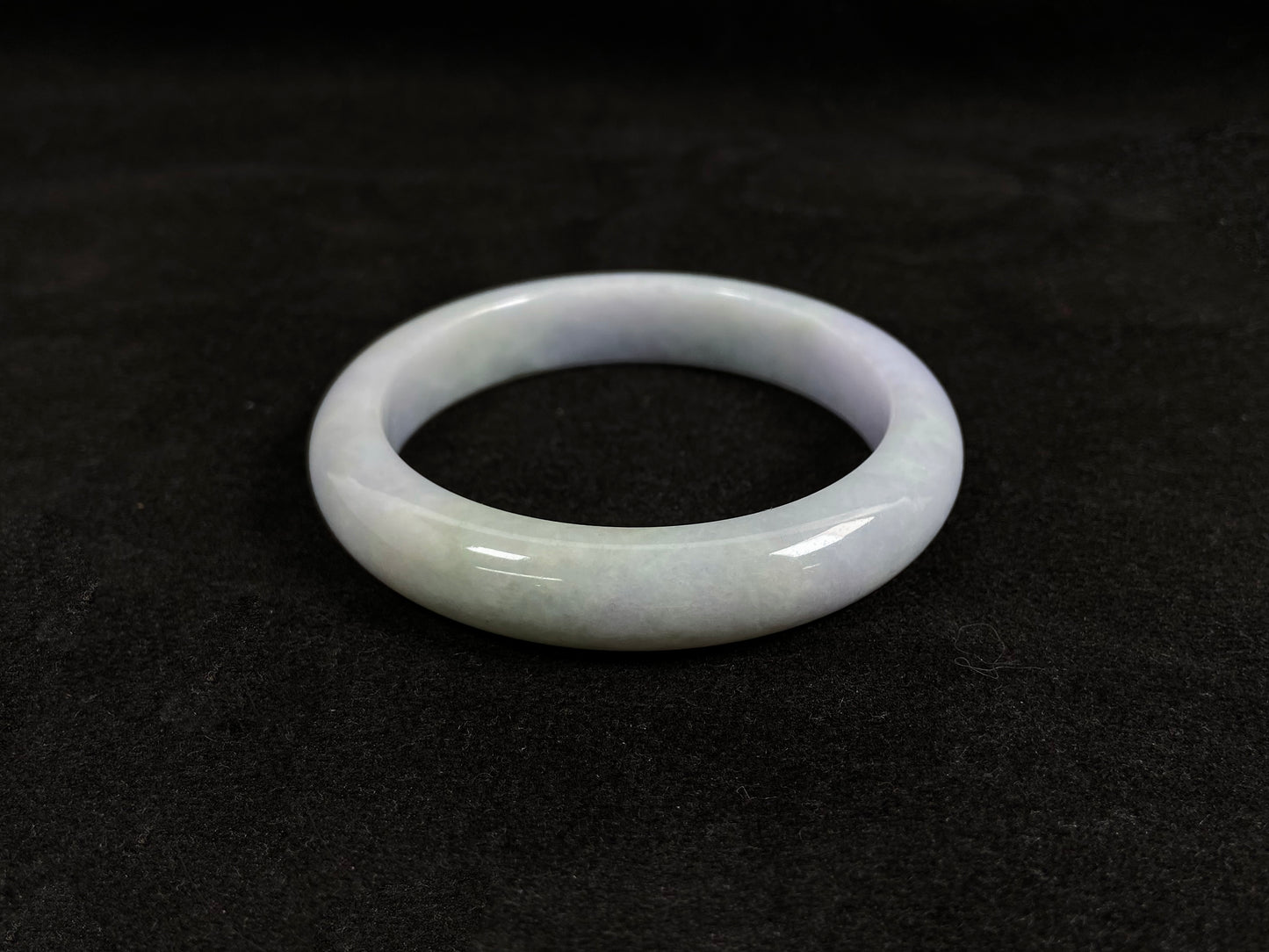 This jadeite bangle blends white and pale purple with golden accents.