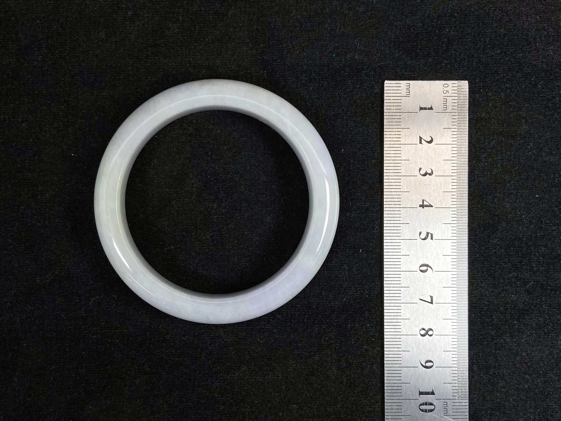 This jadeite bangle blends white and pale purple with golden accents.