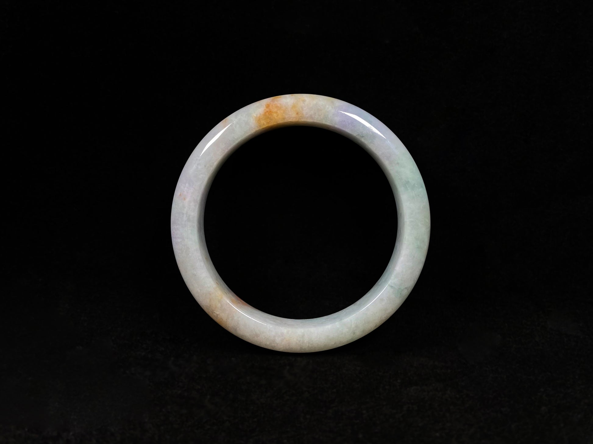 This tricolor jadeite bangle combines yellow, purple, and green, symbolizing fortune, prosperity, and longevity.
