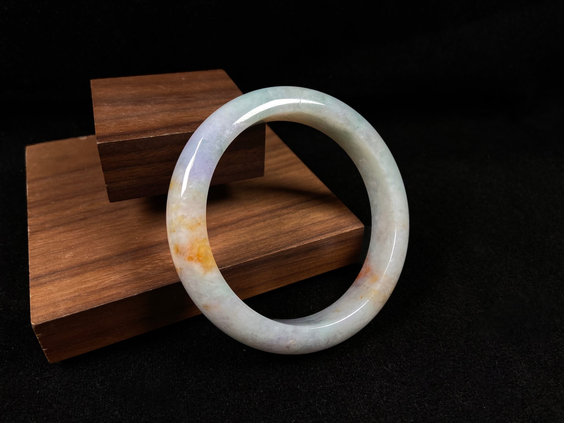 This tricolor jadeite bangle combines yellow, purple, and green, symbolizing fortune, prosperity, and longevity.