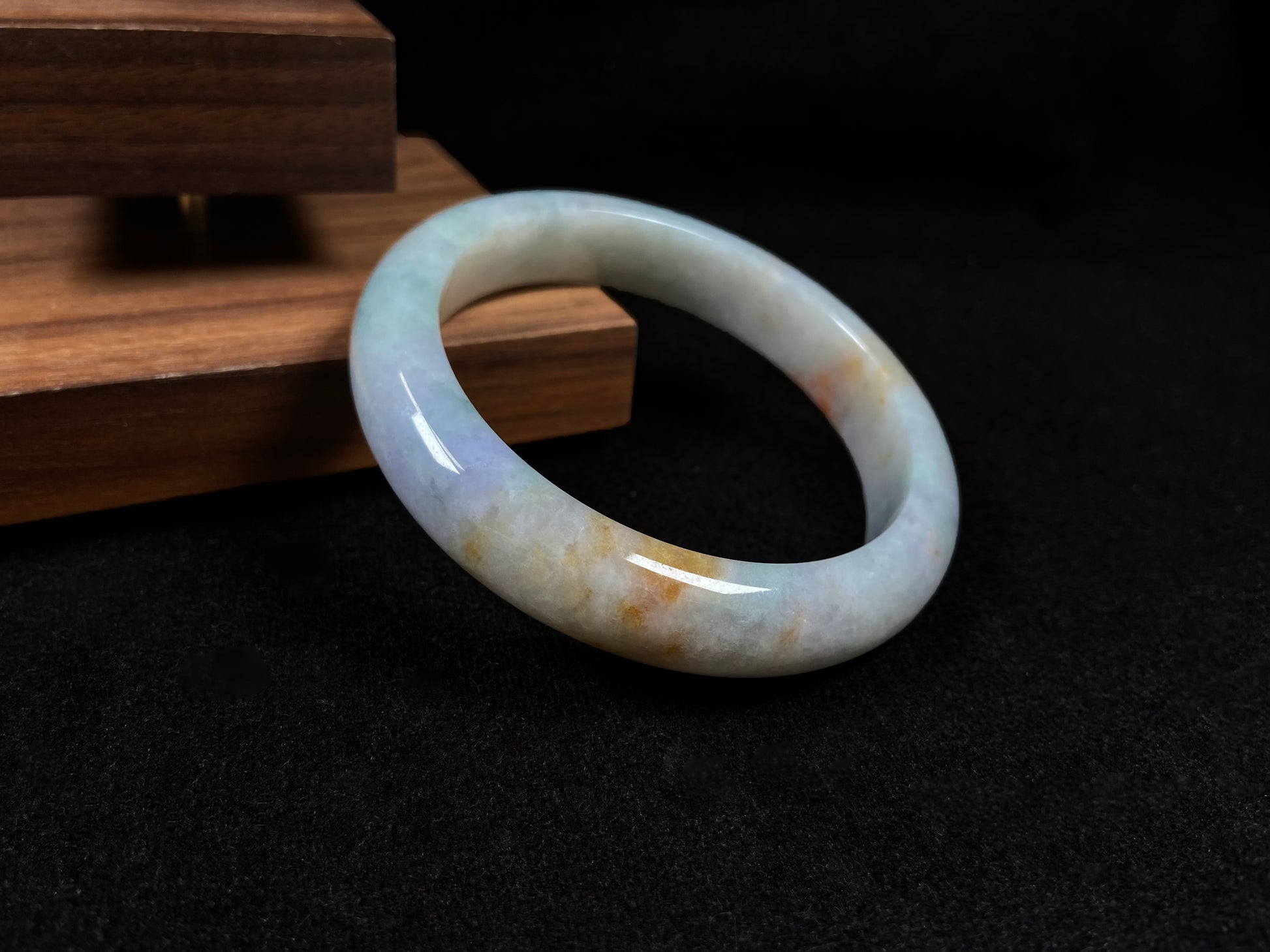 This tricolor jadeite bangle combines yellow, purple, and green, symbolizing fortune, prosperity, and longevity.