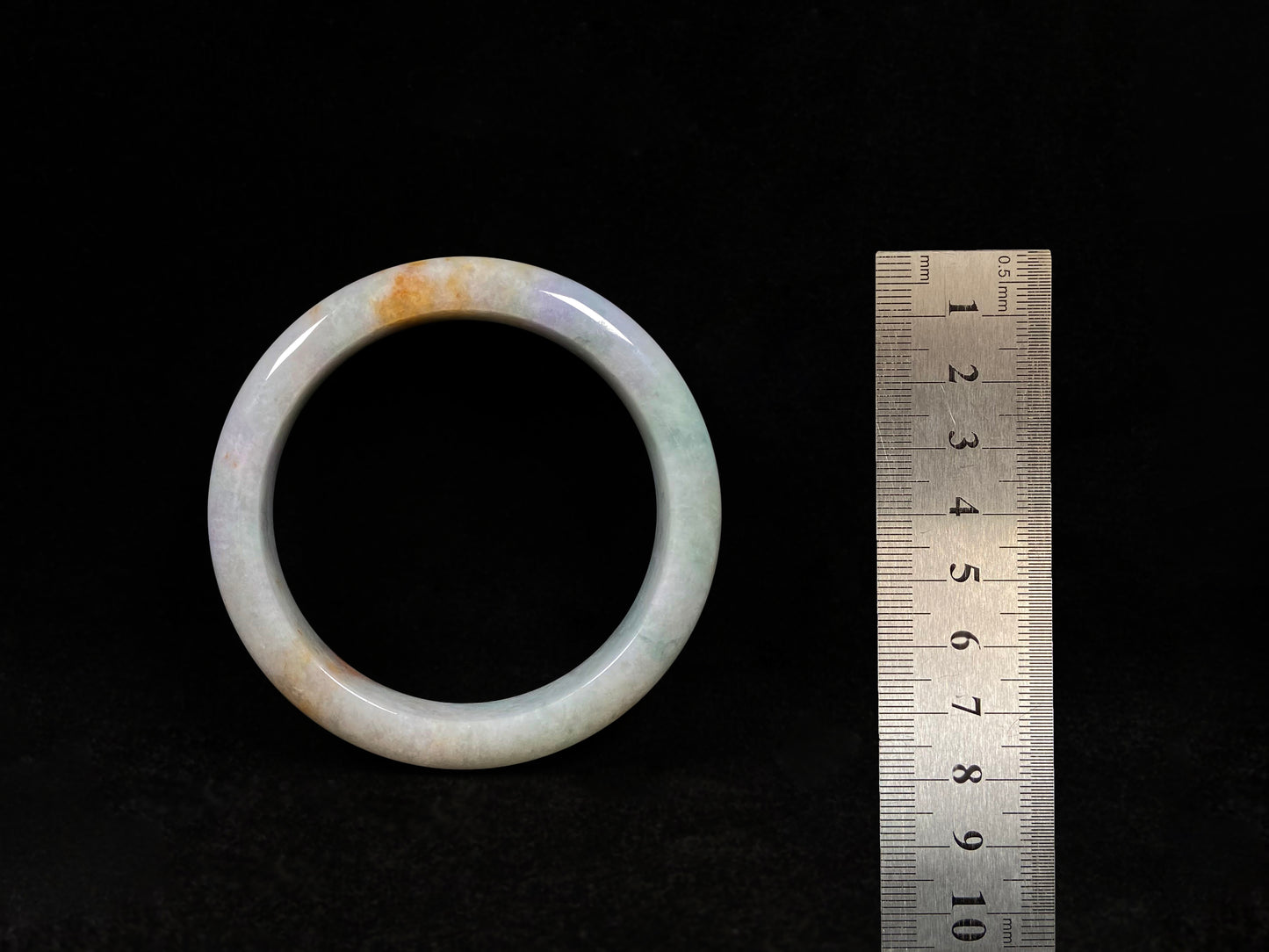 This tricolor jadeite bangle combines yellow, purple, and green, symbolizing fortune, prosperity, and longevity.