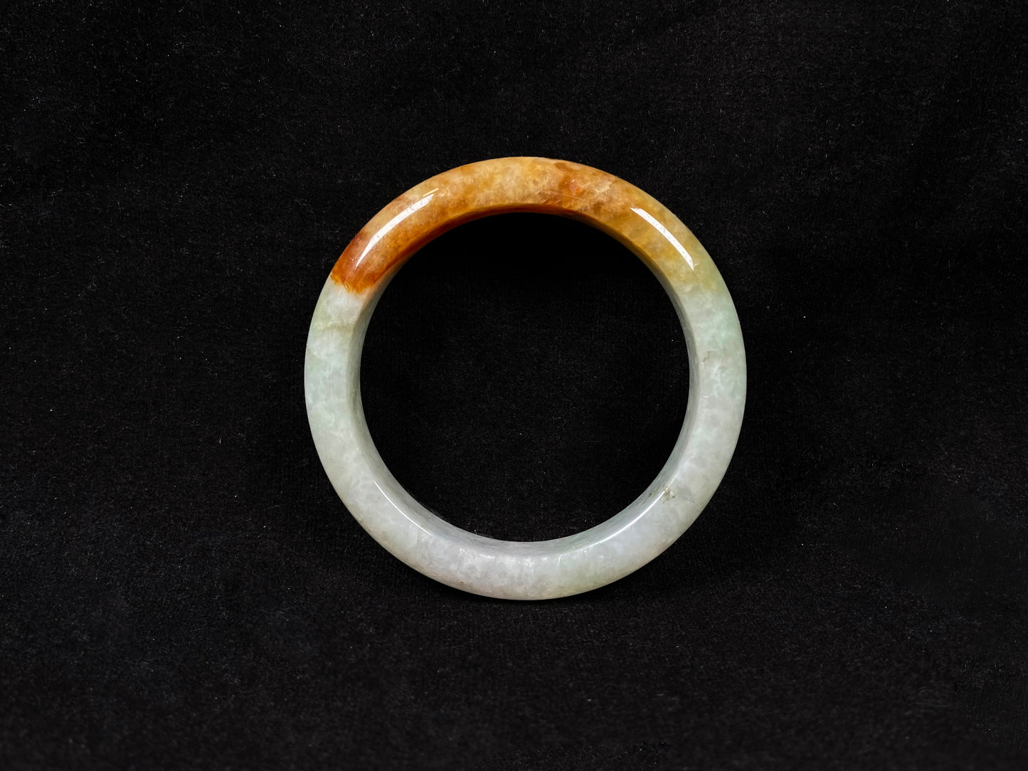 This elegant jadeite bangle features a harmonious blend of yellow, white, and light green tones.