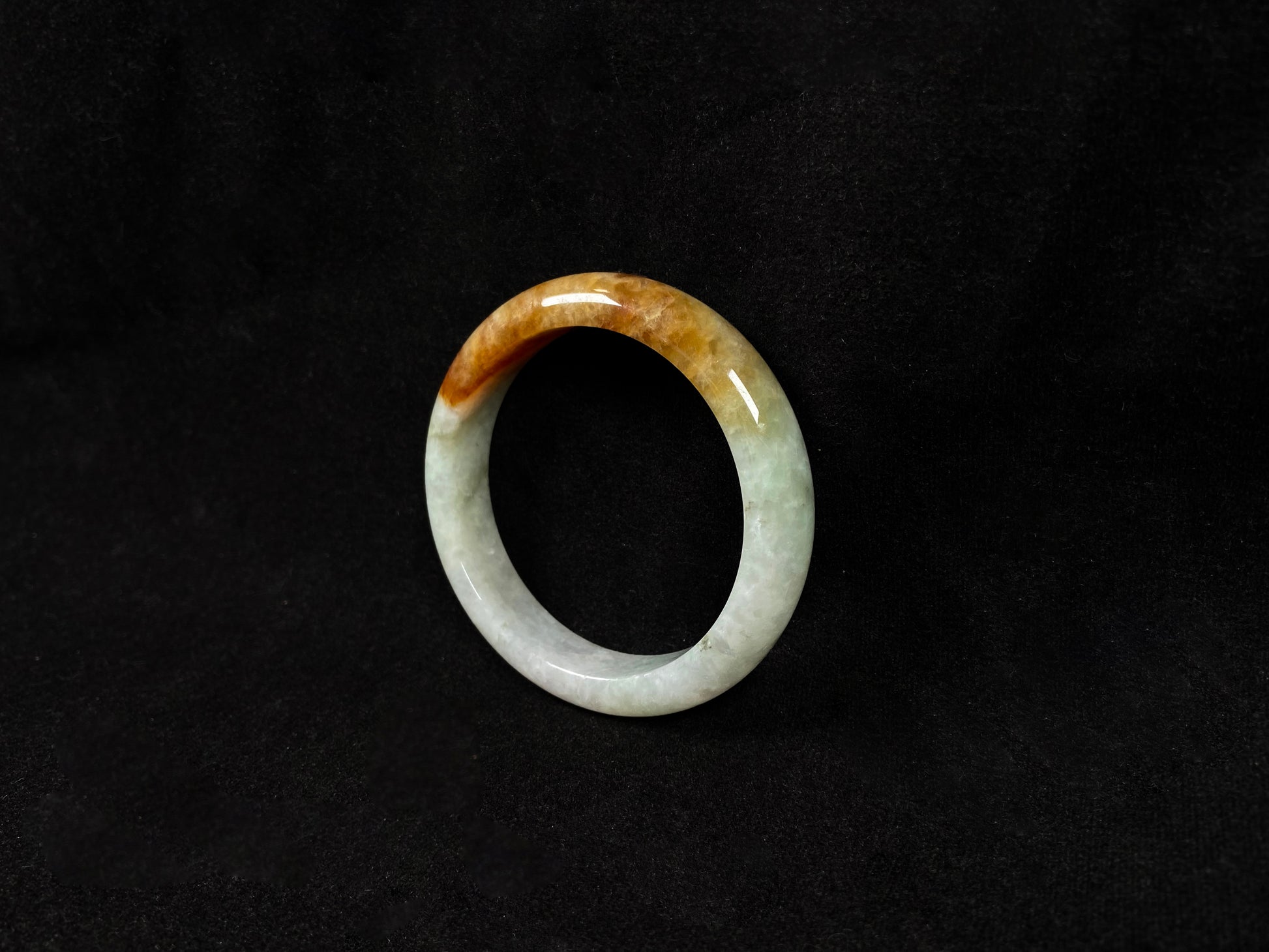 This elegant jadeite bangle features a harmonious blend of yellow, white, and light green tones.