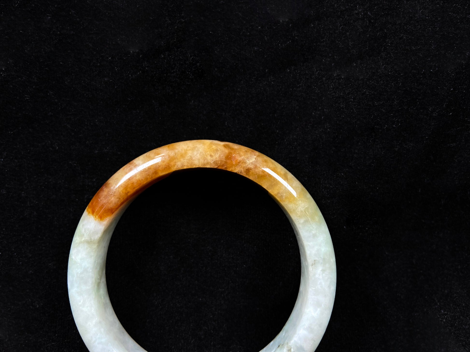 This elegant jadeite bangle features a harmonious blend of yellow, white, and light green tones.