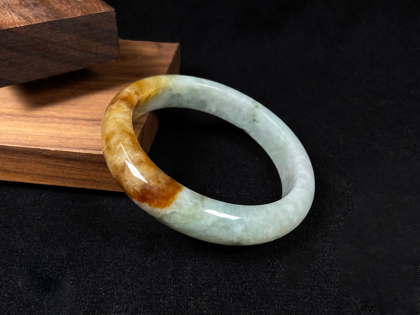 This elegant jadeite bangle features a harmonious blend of yellow, white, and light green tones.