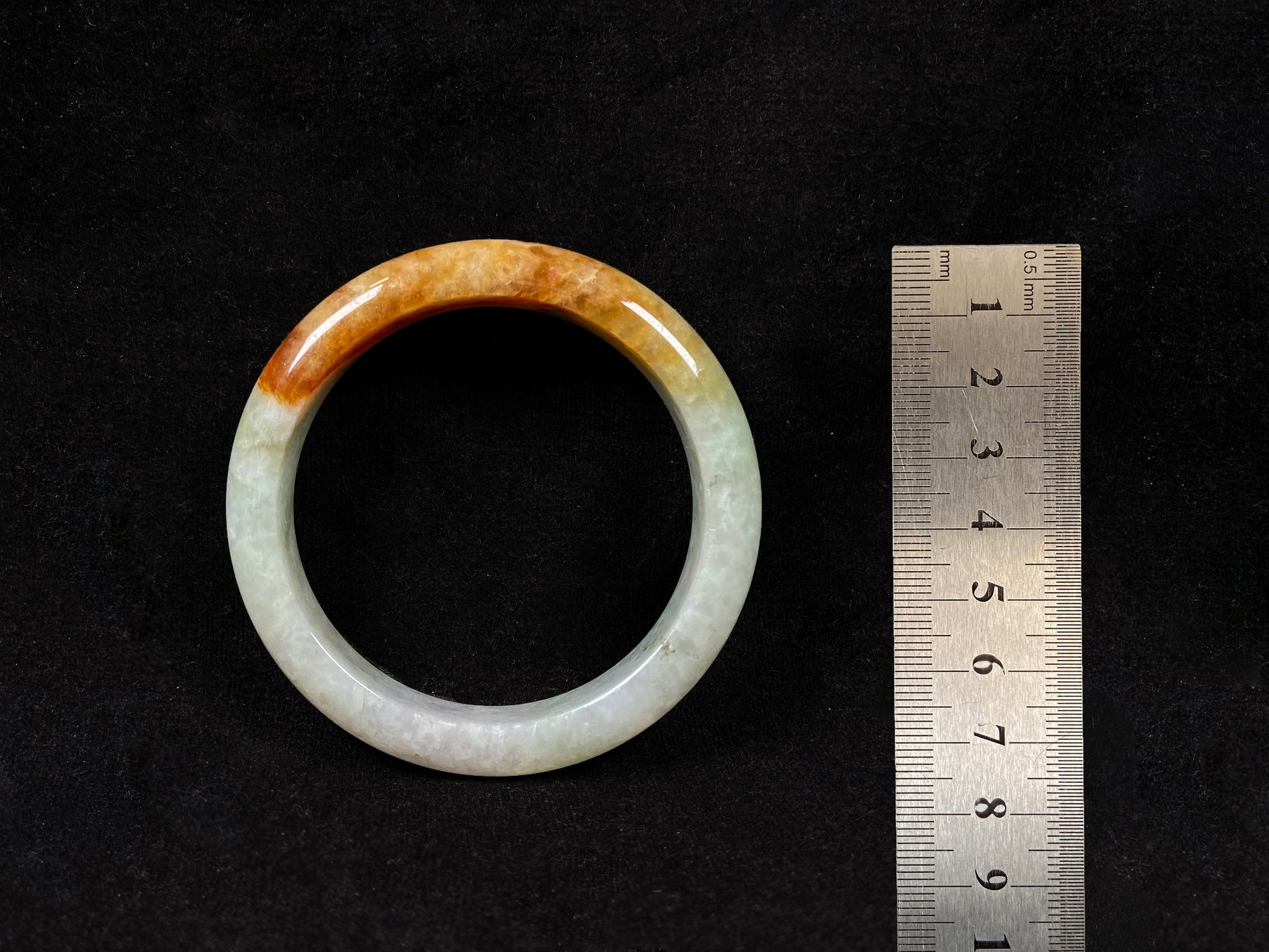 This elegant jadeite bangle features a harmonious blend of yellow, white, and light green tones.