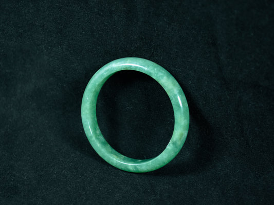 Green jade ring on a black background