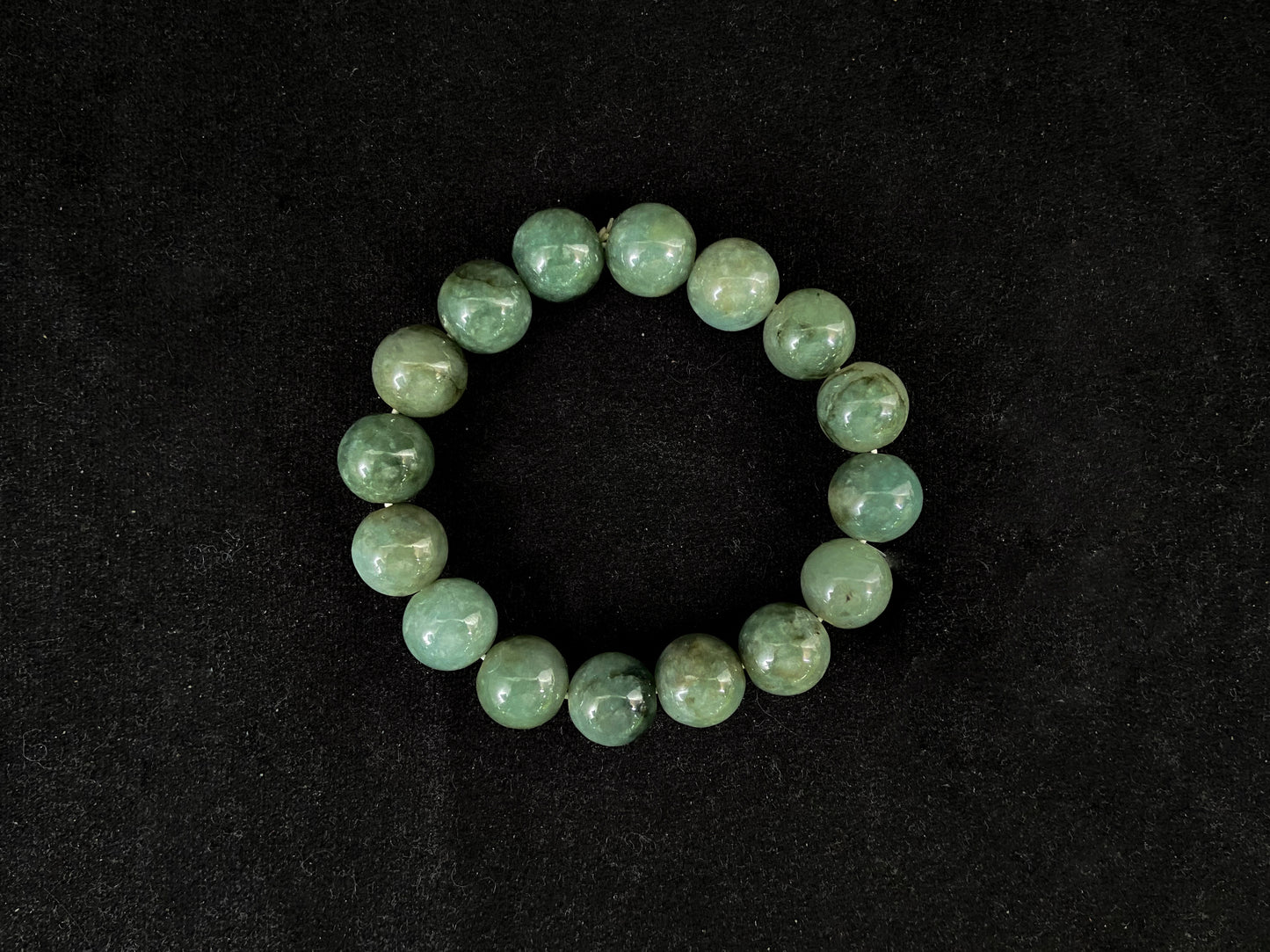 This jadeite strand consists of consistent sized beads with a green base.