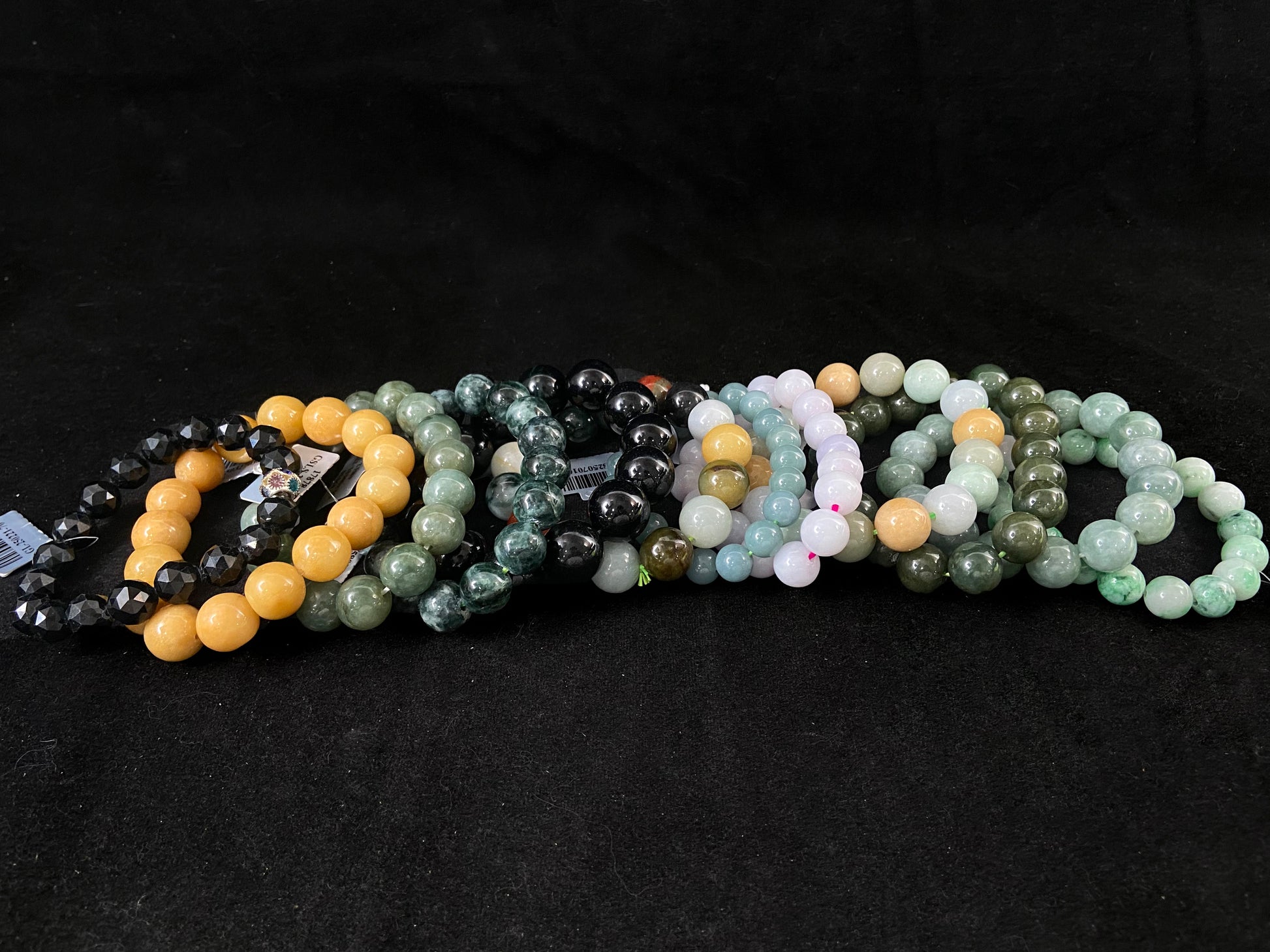 A collection of 12 jade bead strands in varied colors.