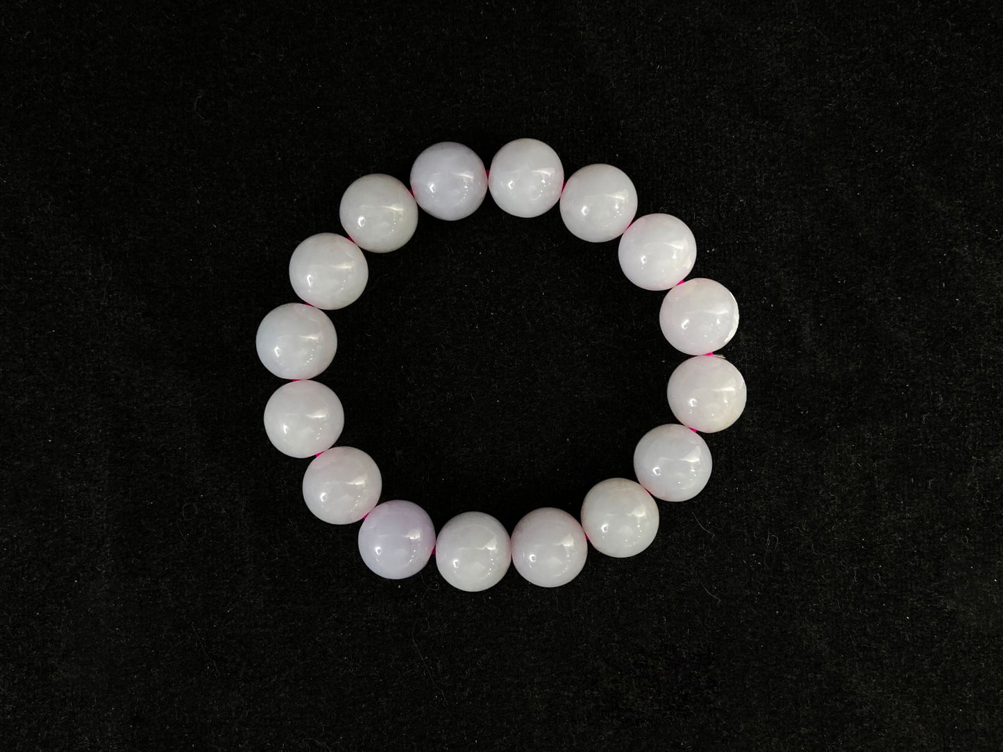This jadeite bead strand is made of beads with a white base and pale purple accents.