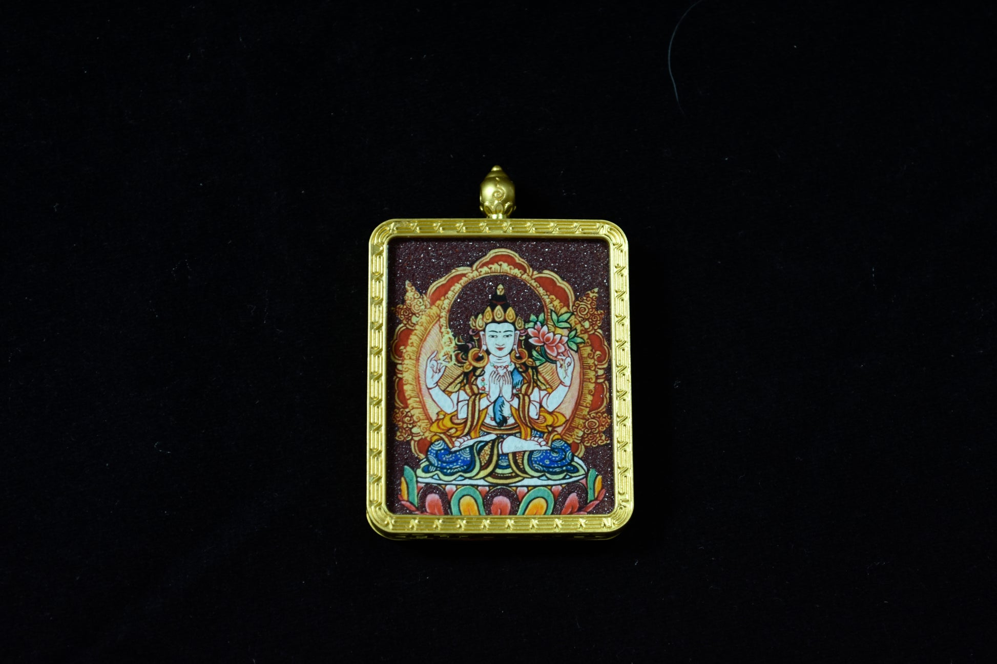 Decorative pendant with a central figure on a black background