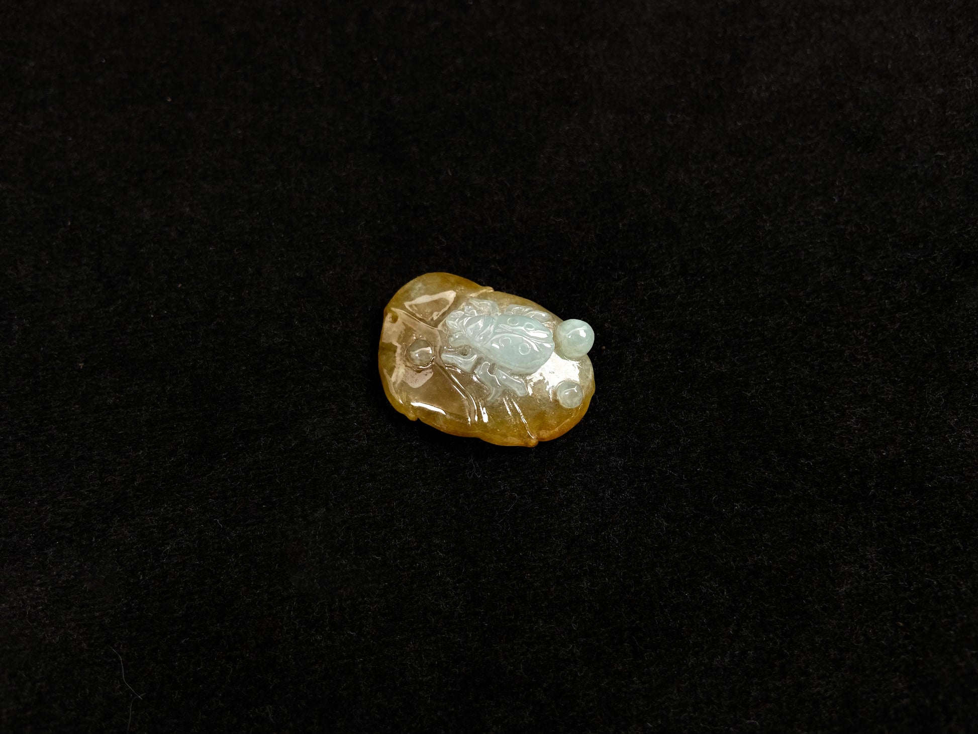 This yellow jadeite features a crawling spider in milky white translucent jadeite.