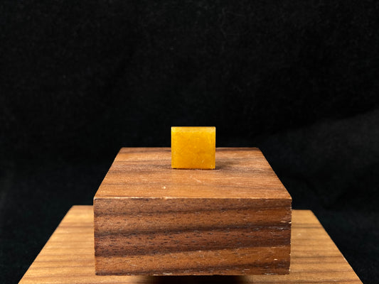 A warm yellow jadeite cut into a charming sugar cube shape.