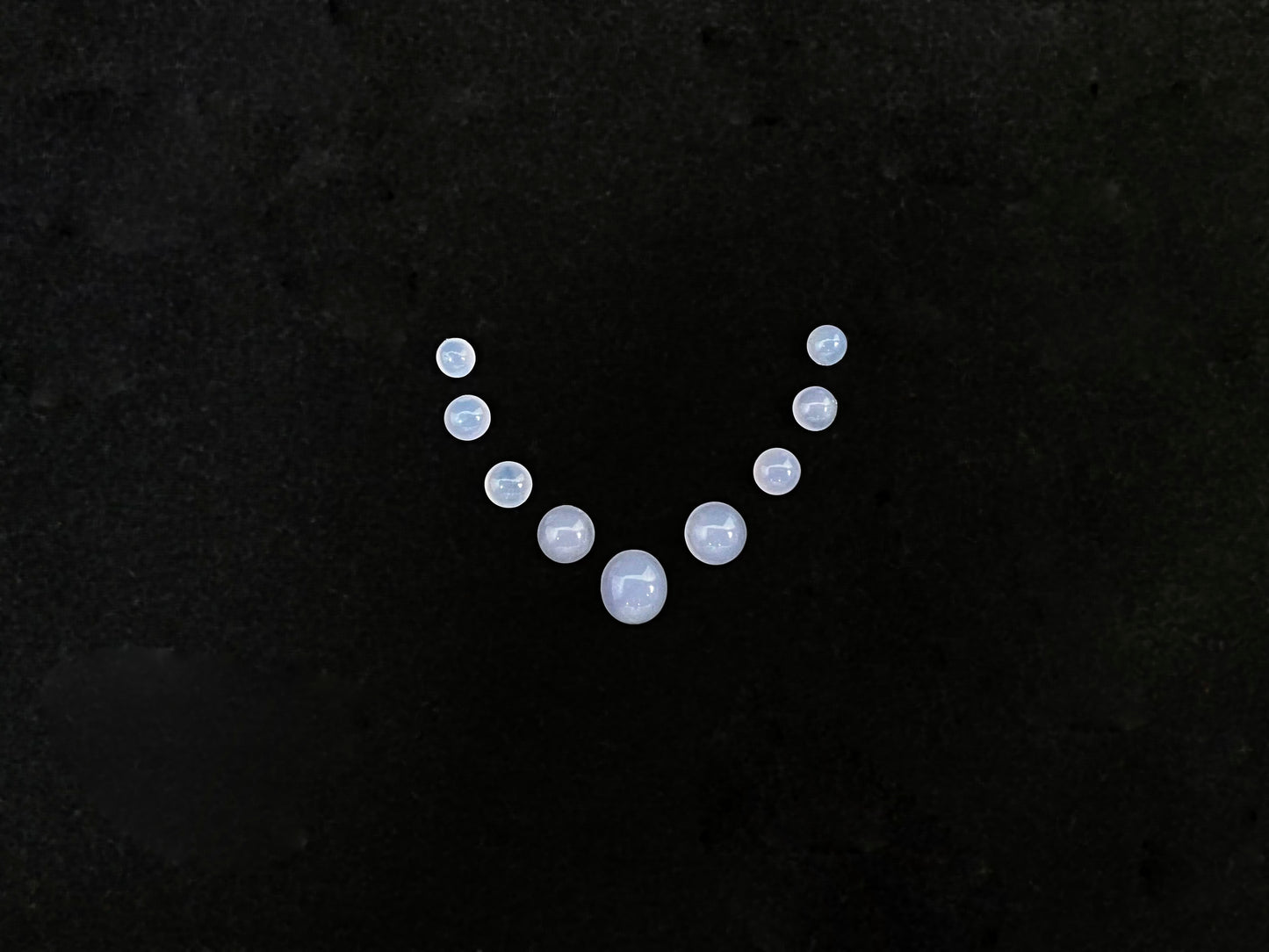 A lavender dewdrop nine stone set loose jadeite.