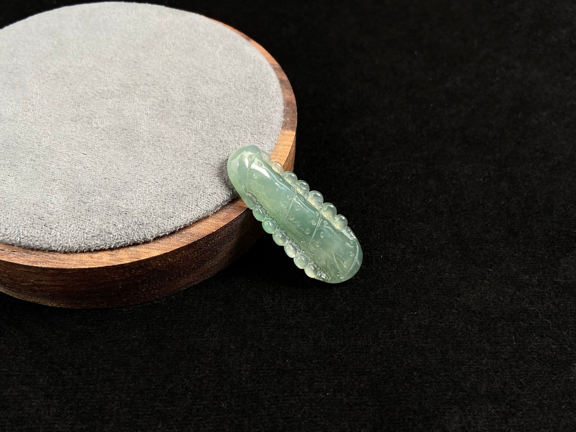 A pale green jadeite loose stone carved in the shape of a bamboo stalk.