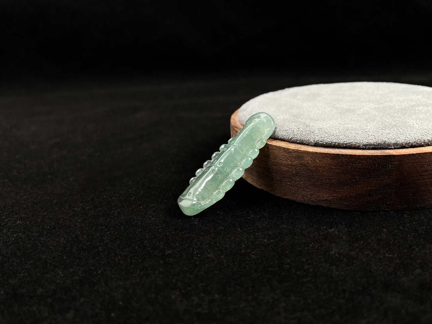 A pale green jadeite loose stone carved in the shape of a bamboo stalk.