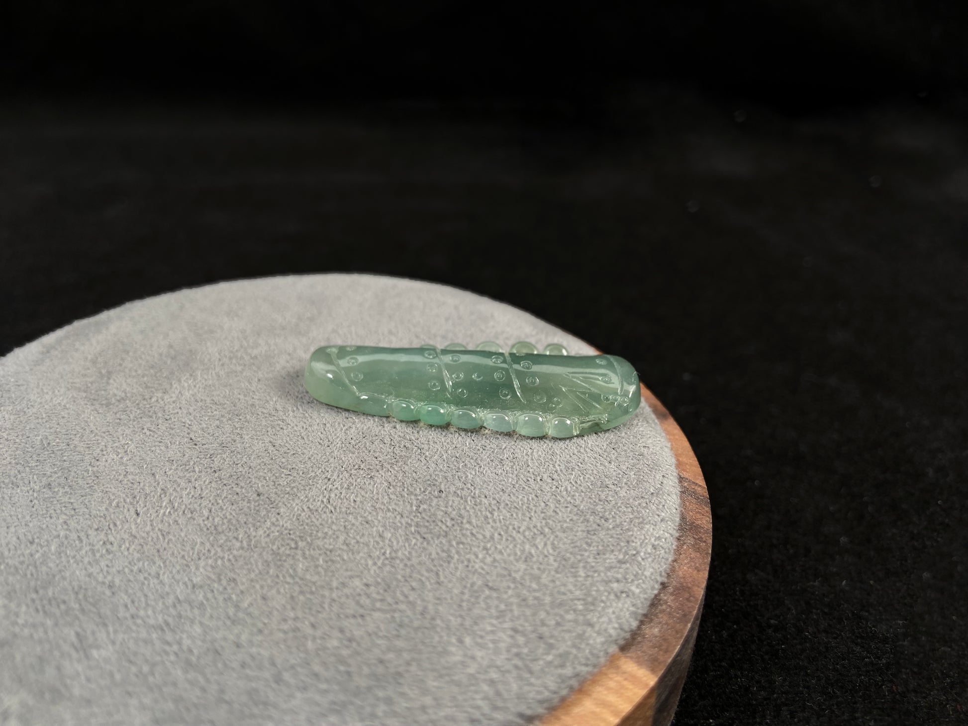 A pale green jadeite loose stone carved in the shape of a bamboo stalk.