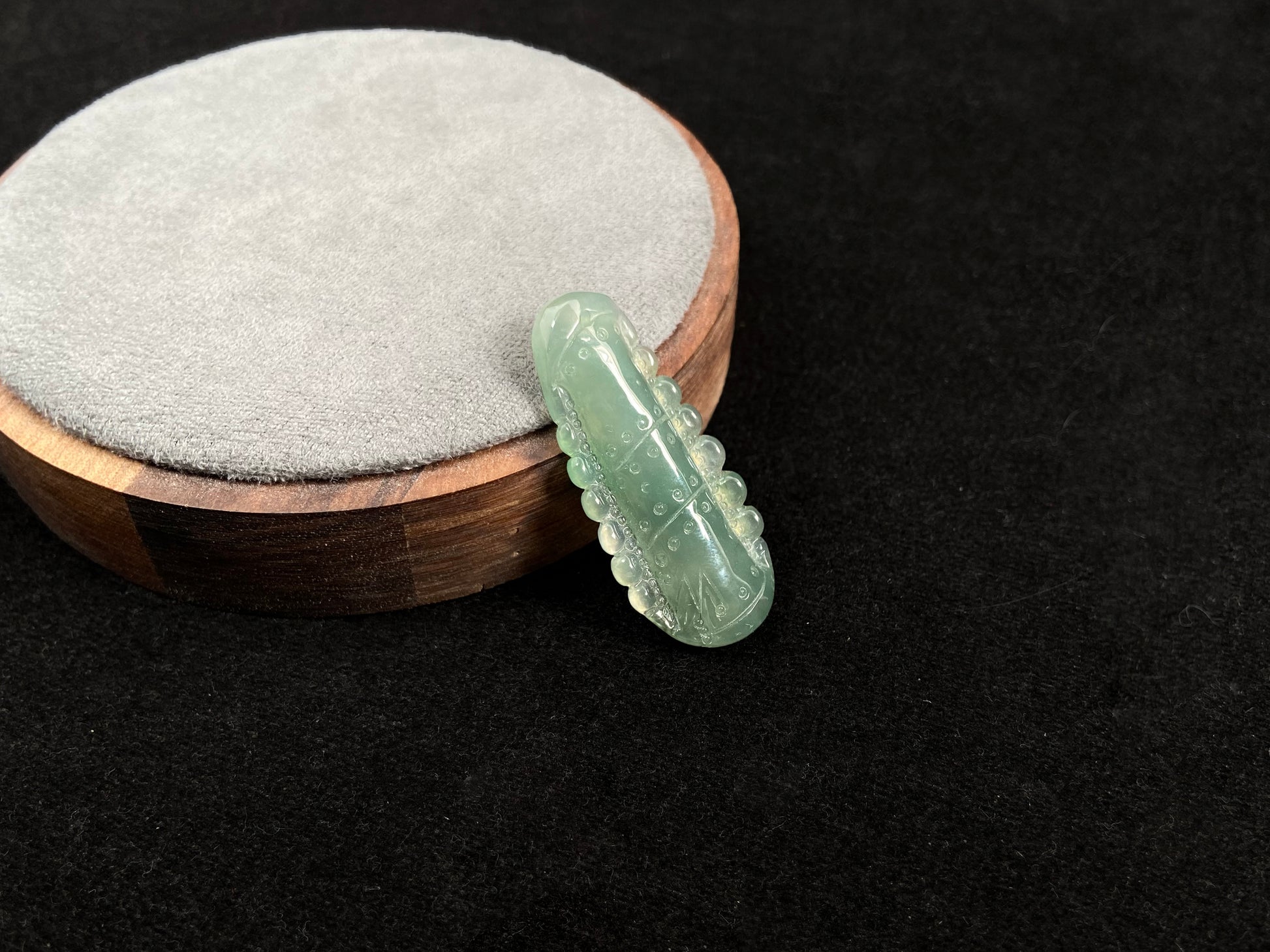 A pale green jadeite loose stone carved in the shape of a bamboo stalk.