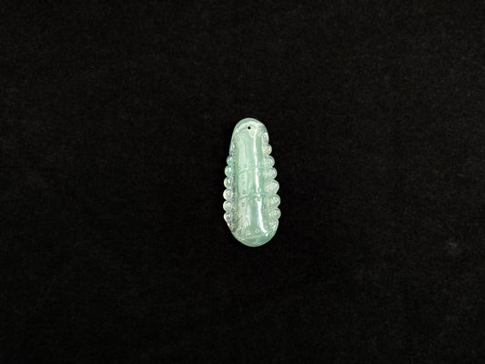 A pale green jadeite losse stone carved in the shape of a bamboo stalk.