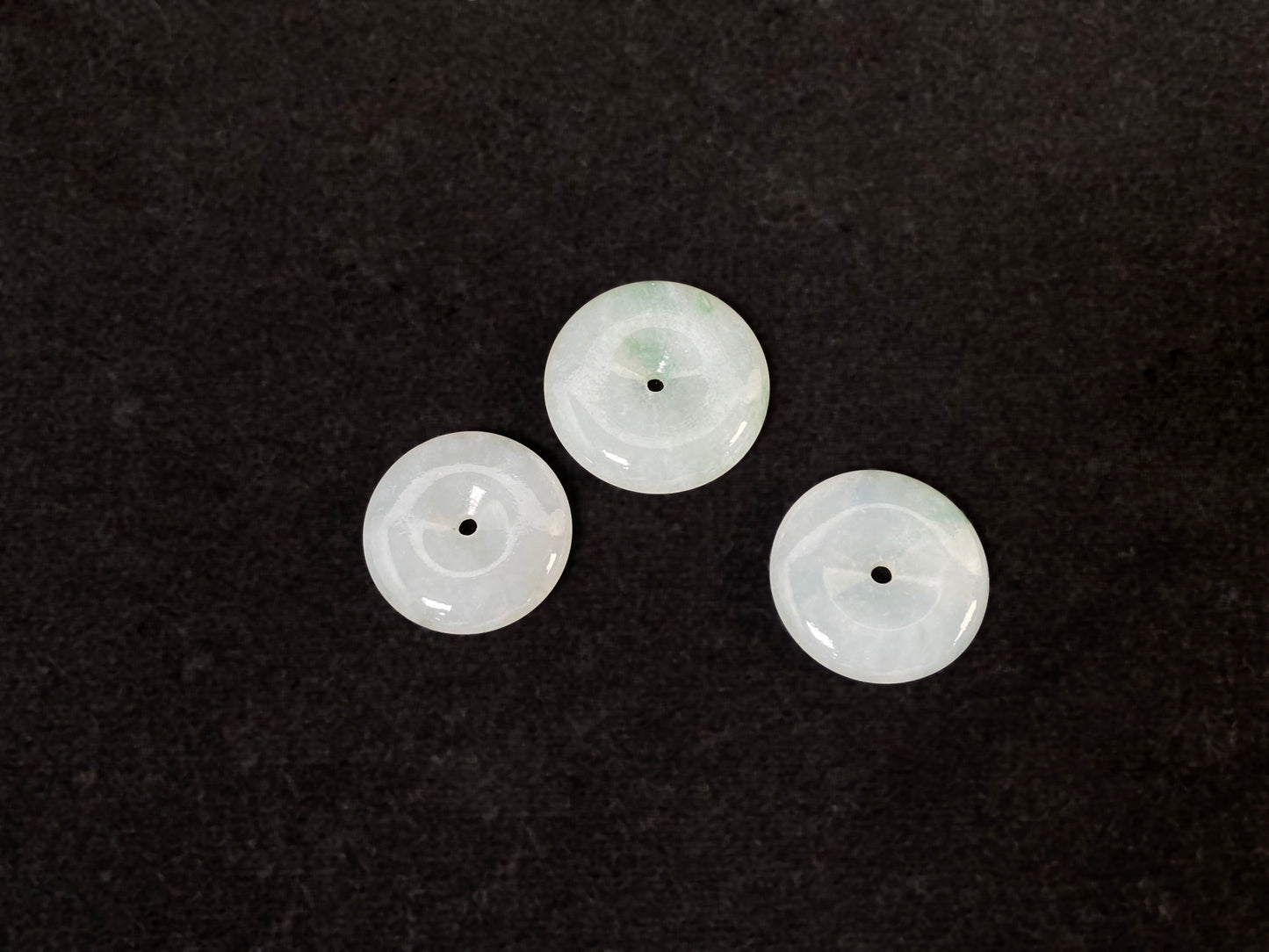 Translucent white jade cabochons featuring soft green patterns.